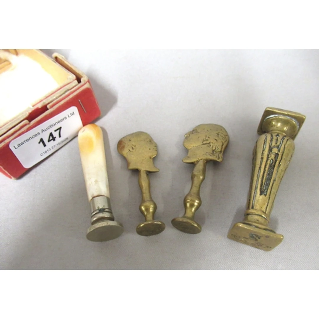 Two antique brass seals, the handles in the form of silhouet...
