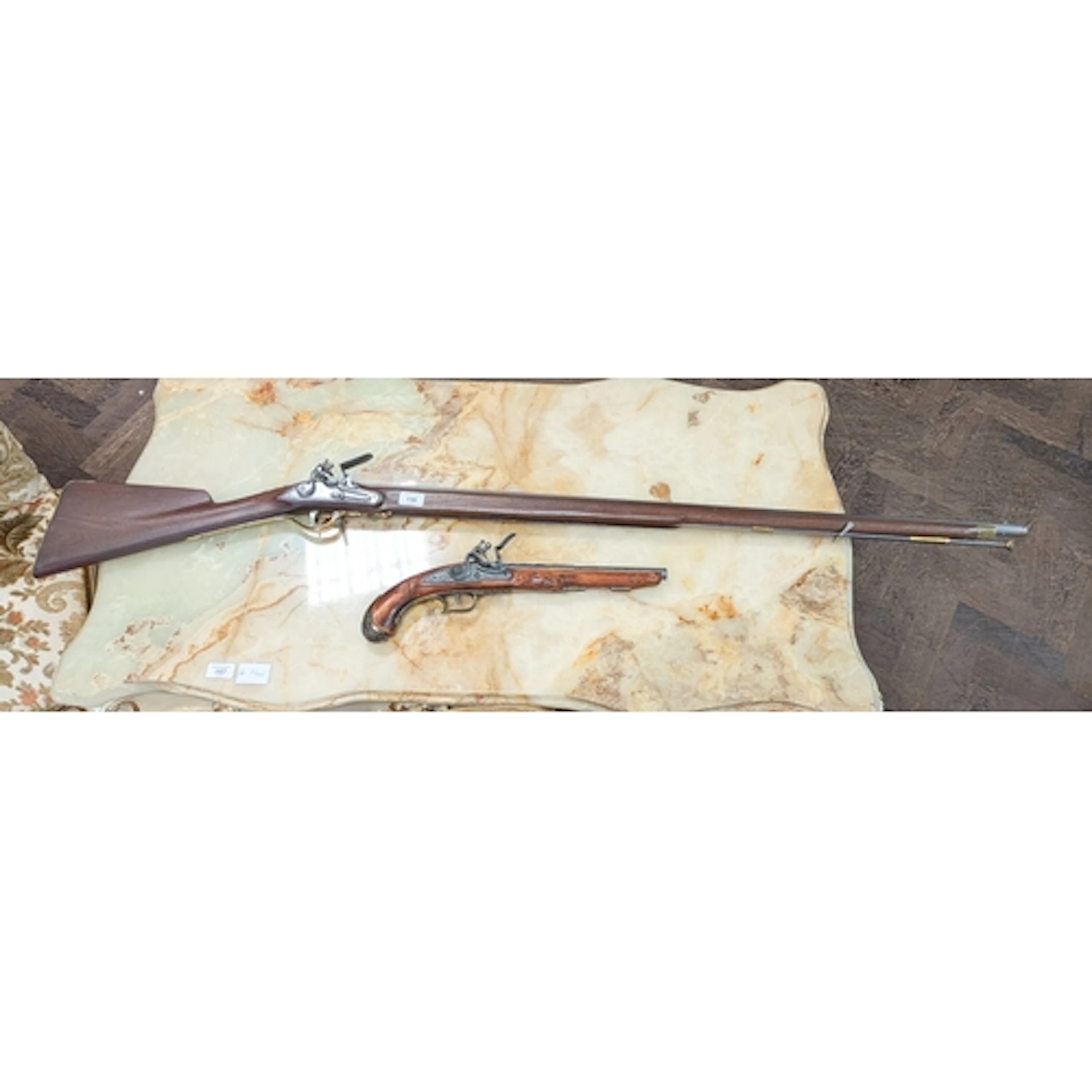 A reproduction antique flint lock musket and a reproduction ...