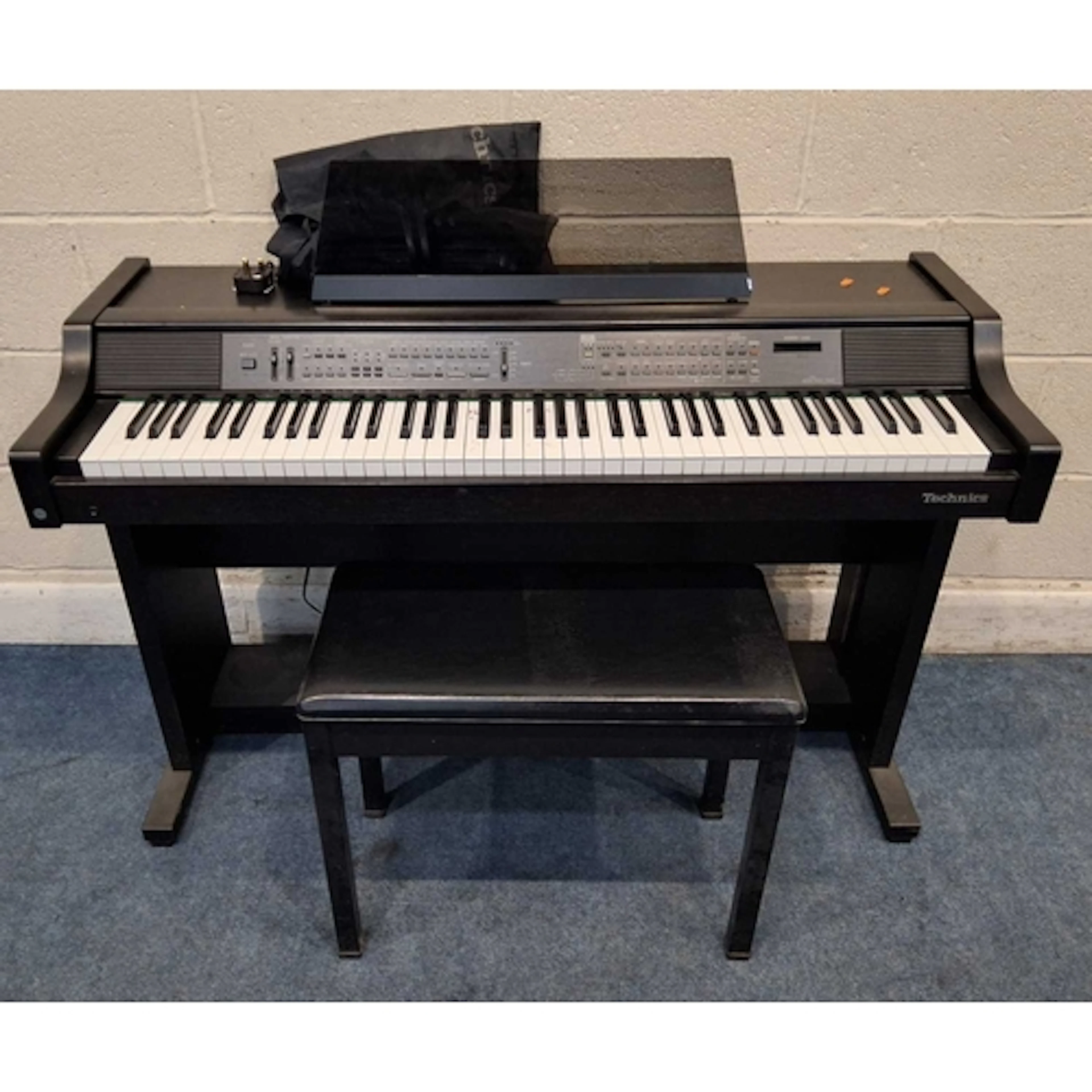 A TECHNICS PR40 DIGITAL PIANO, with a control panel and two ...