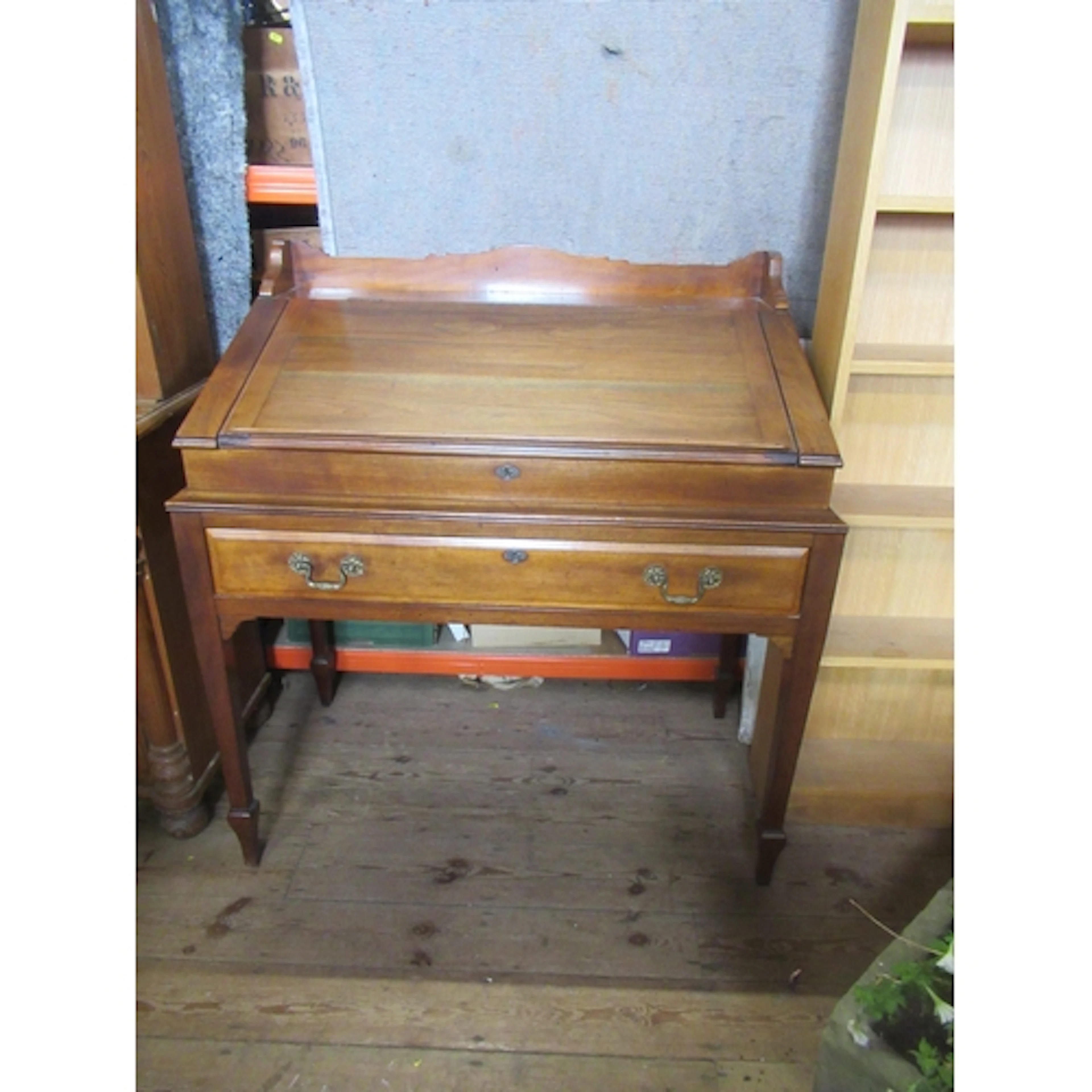 An antique mahogany desk, the hinged sloping writing surface...