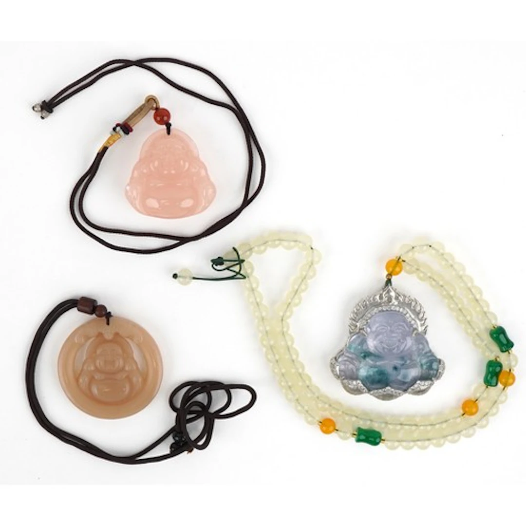 Three Chinese carved stone and composite pendants in the for...