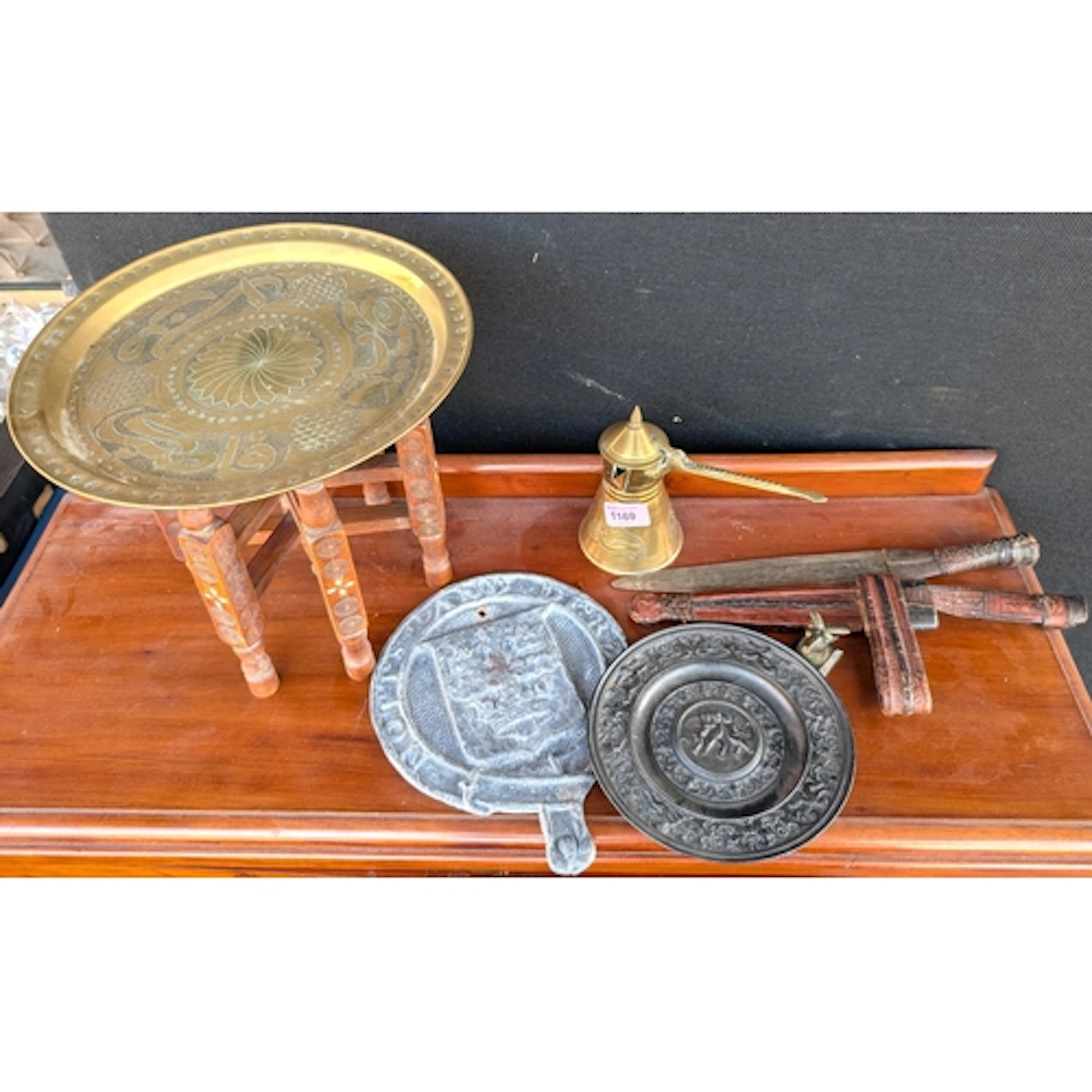 A Middle Eastern brass coffee pot, a similar folding table a...