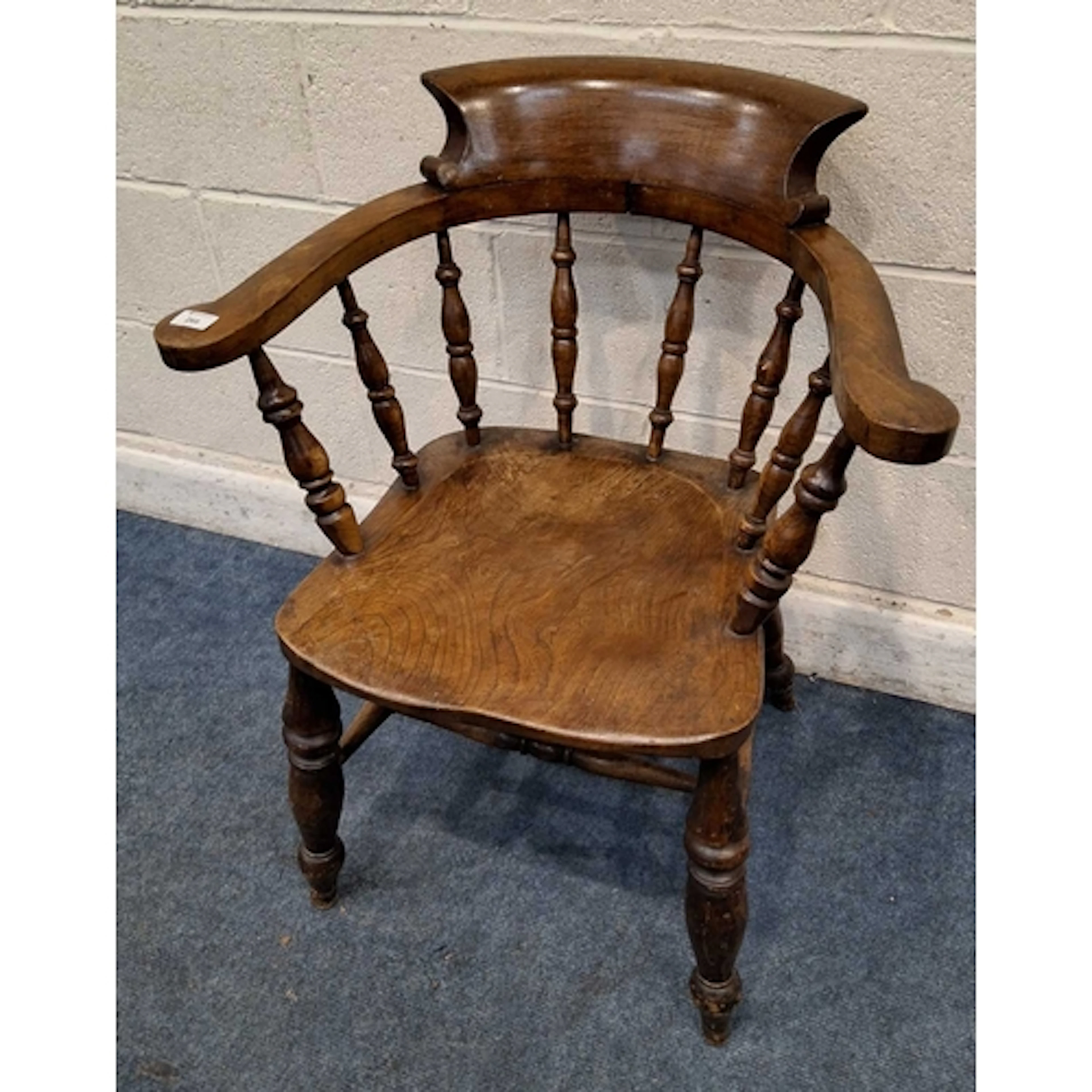 AN EARLY 20TH CENTURY ELM BOW TOP CAPTAINS CHAIR, with outsw...