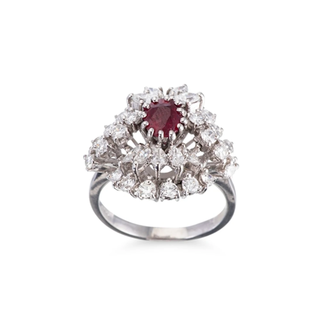A RUBY AND DIAMOND SET CLUSTER RING, the central ruby to mar...