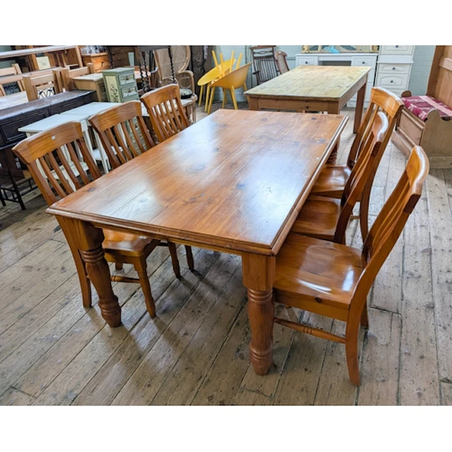 A polished pine dining table on turned legs, together with s...