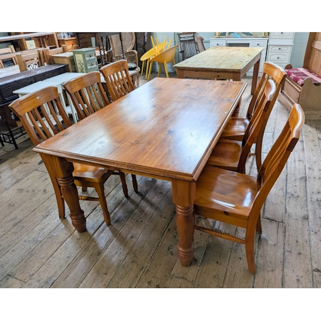 A polished pine dining table on turned legs, together with s...