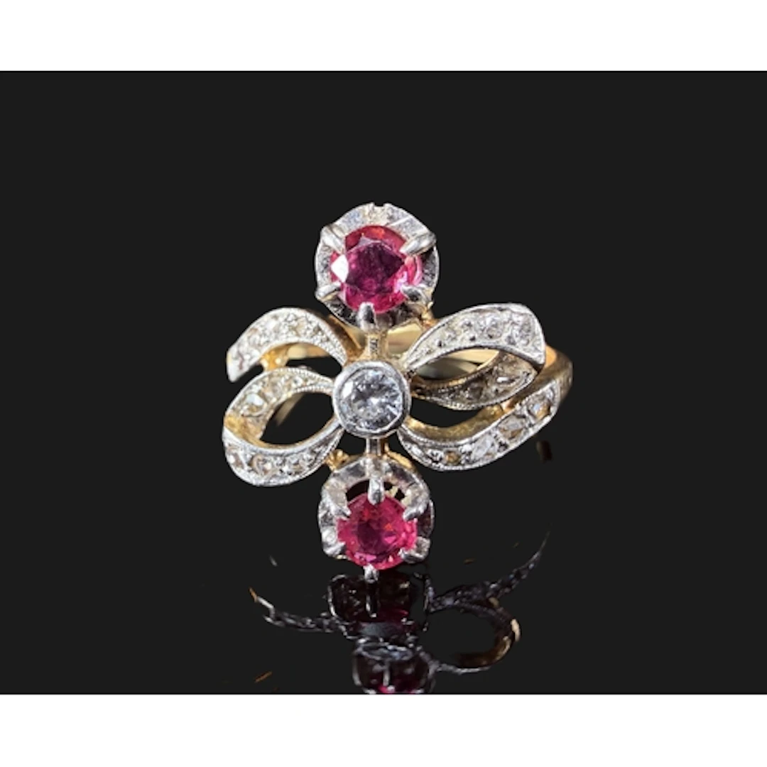 A yellow metal dress ring in bow design set rose and old cut...