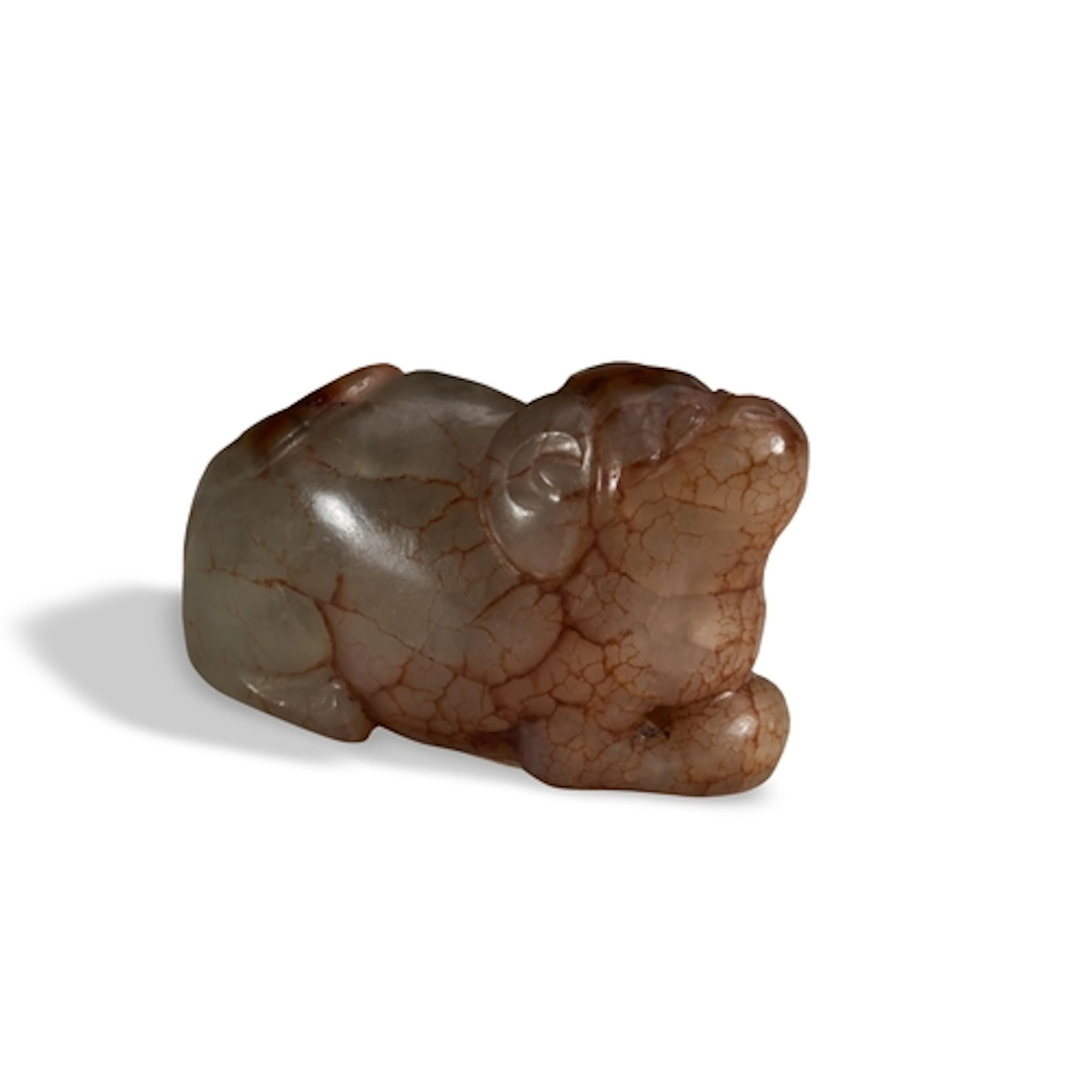 A CRACKLED CELADON AND RUSSET JADE 'DOG' PENDANT 19TH / 20TH...