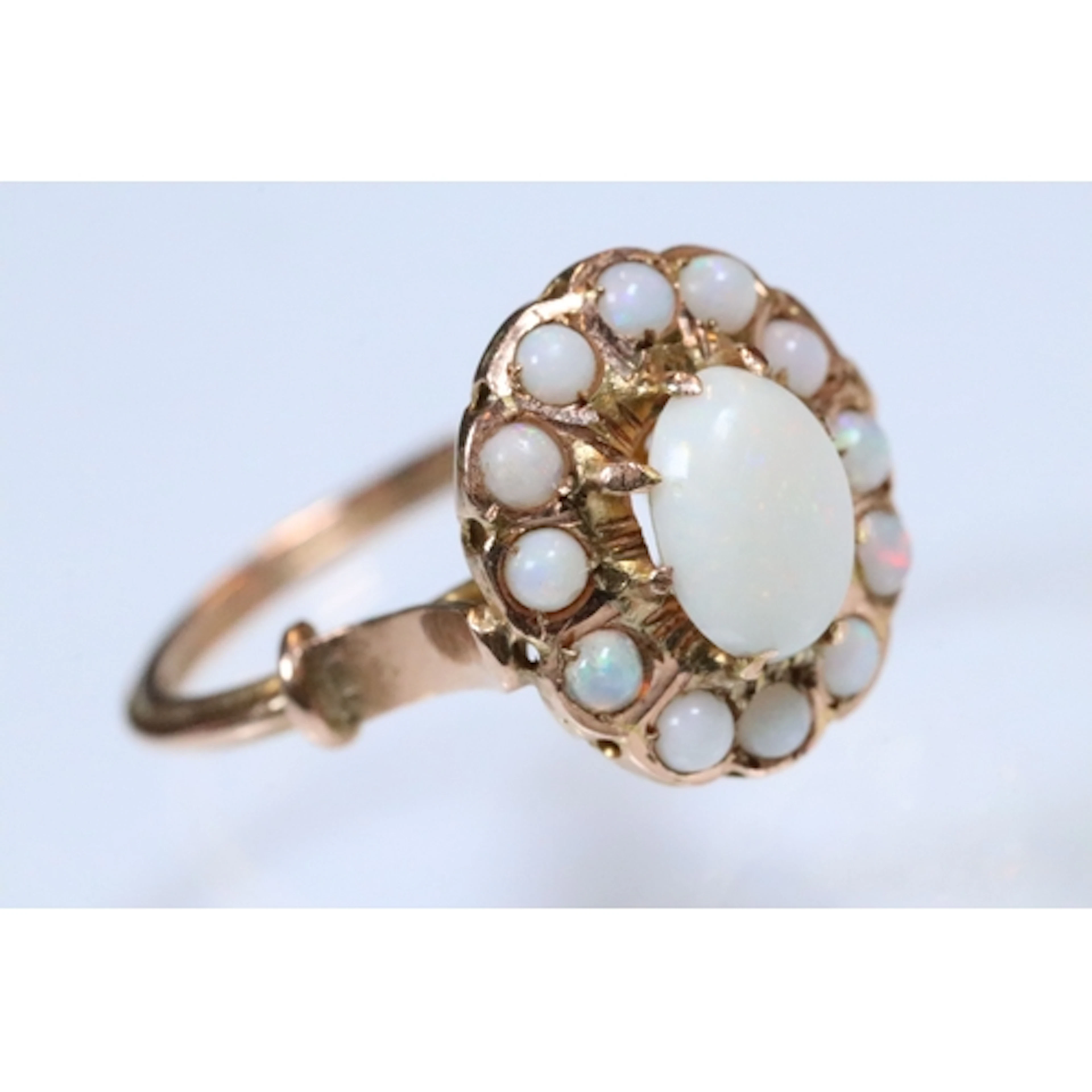 Opal cluster ring having an oval opal cabachon to centre wit...