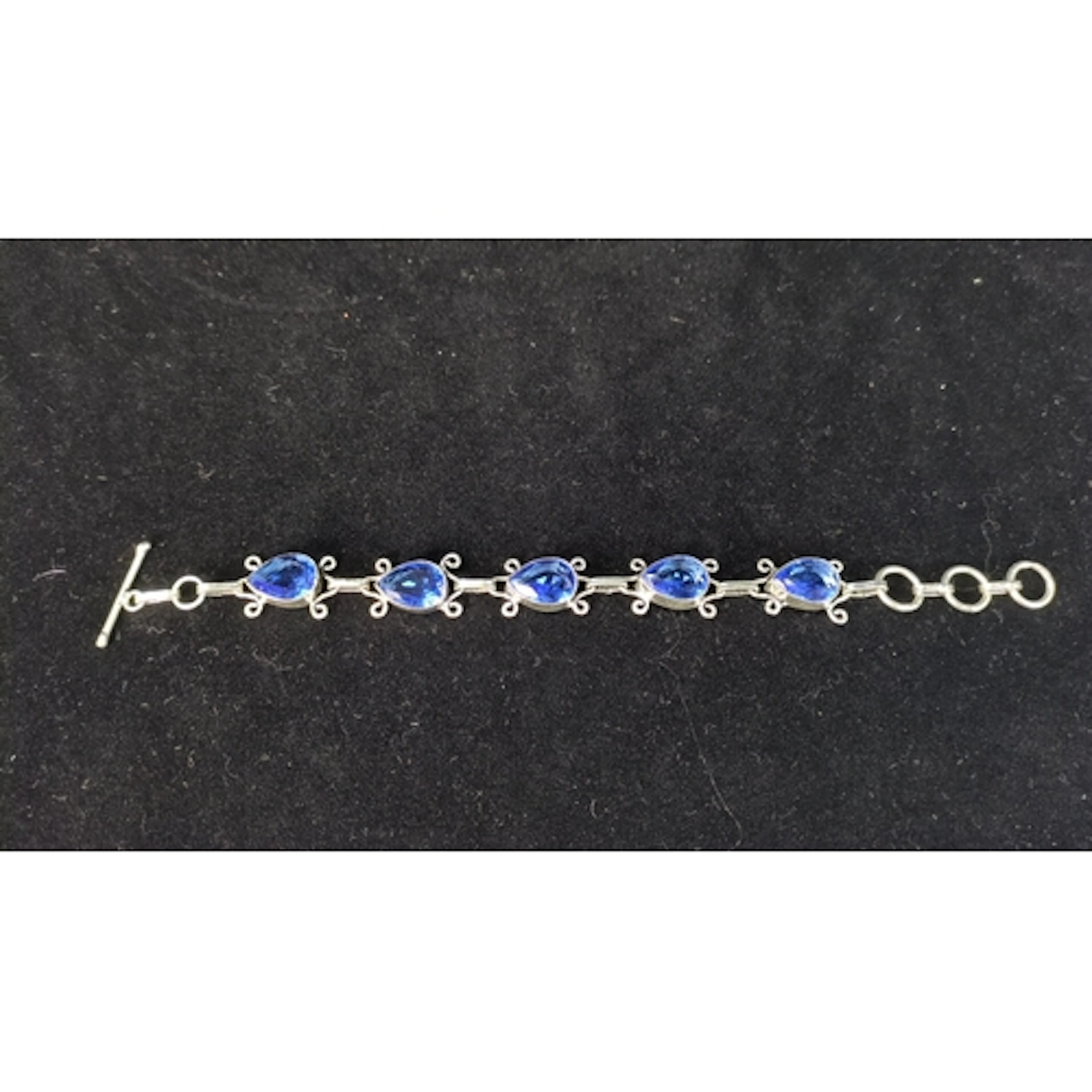 Silver (925) bracelet set with five faceted pear-shaped blue...