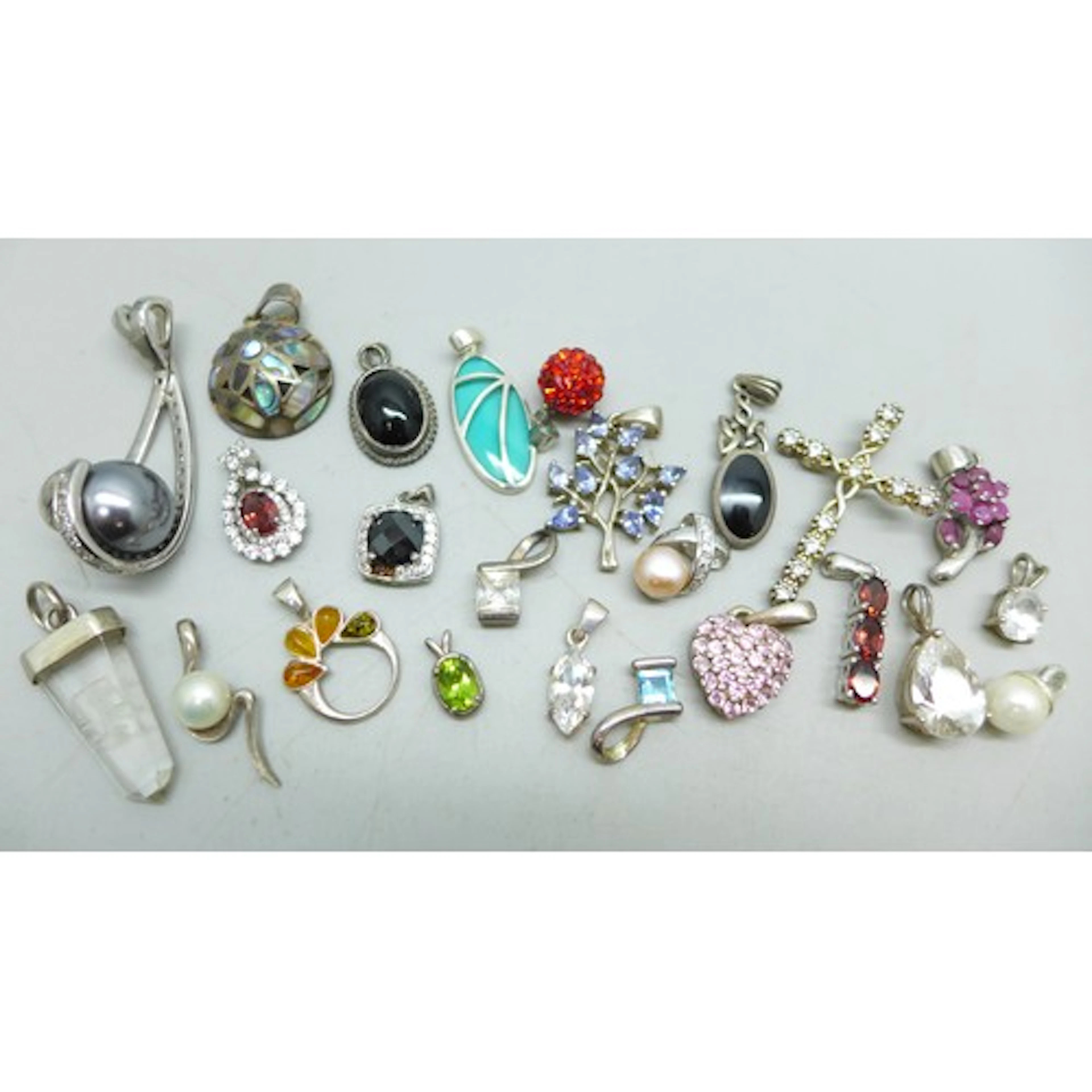 A collection of silver and white metal pendants, and a few s...