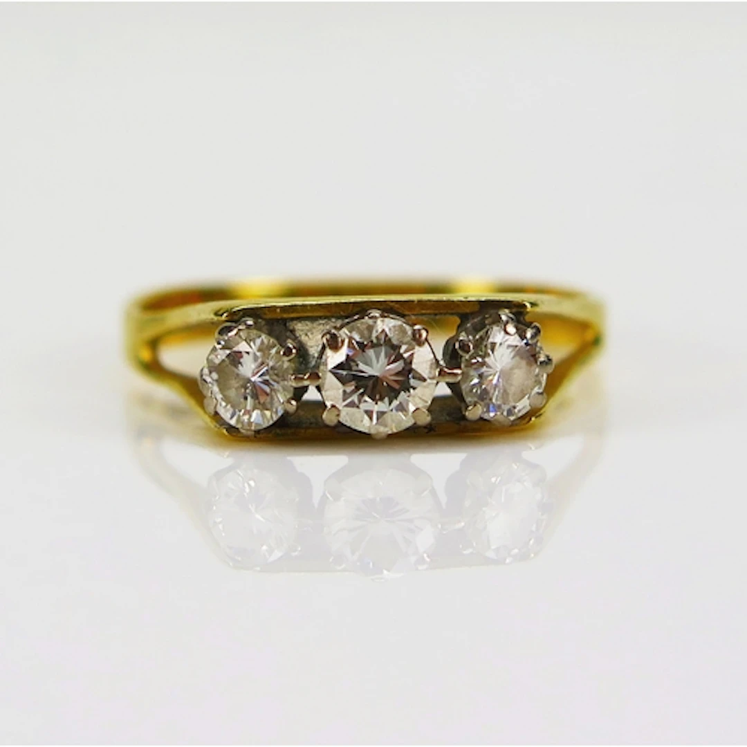 A three stone brilliant round cut diamond ring in an 18ct ye...