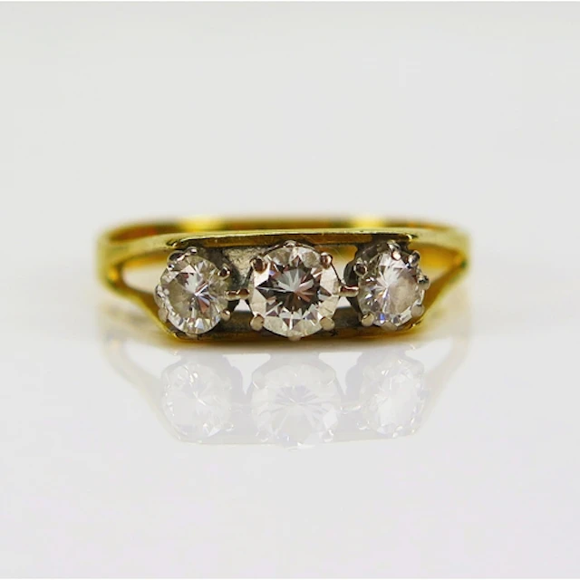 A three stone brilliant round cut diamond ring in an 18ct ye...