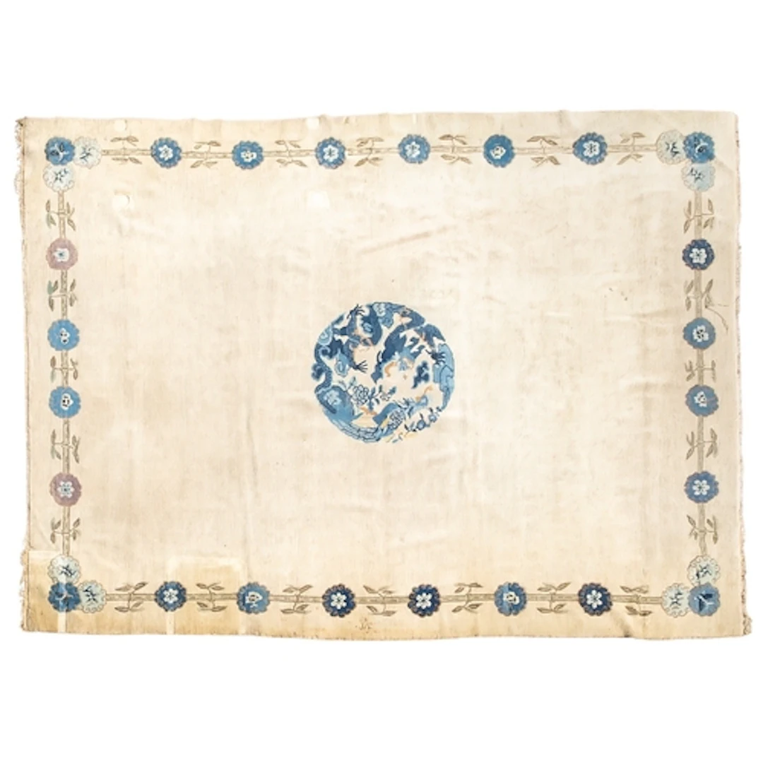 A Chinese carpet, the beige field with a circular central bl...