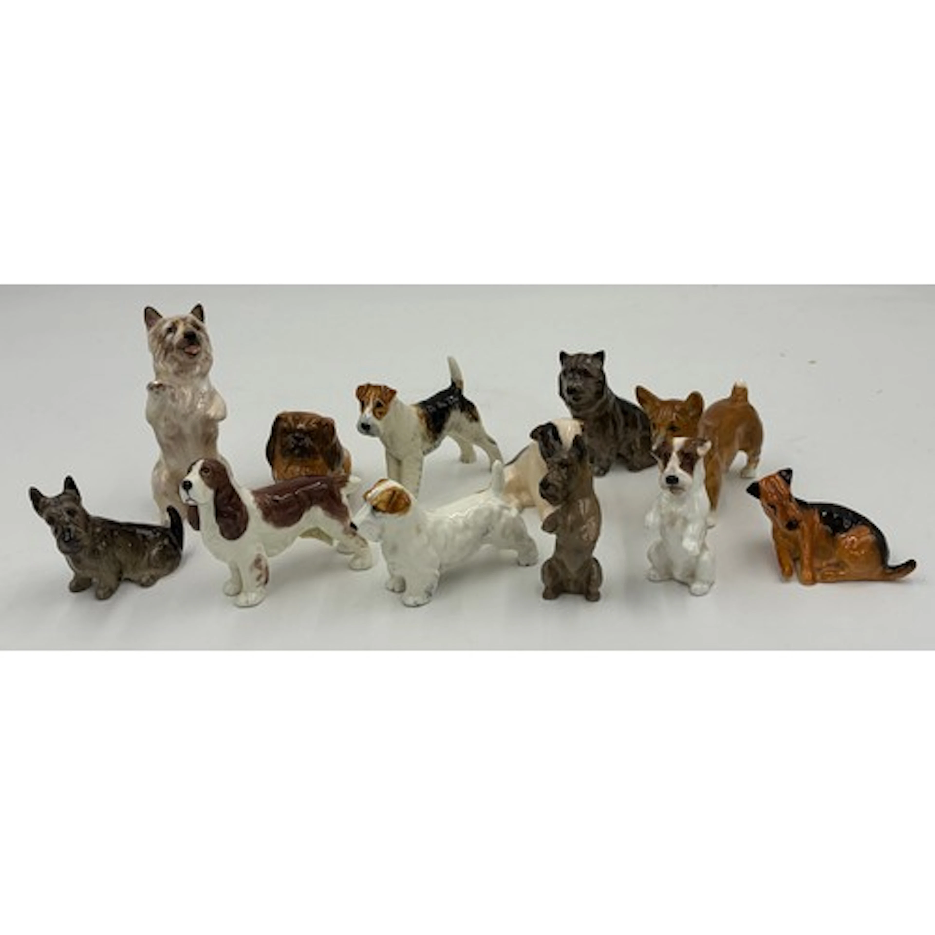 A collection of miniature Royal Doulton dogs to include: Pek...