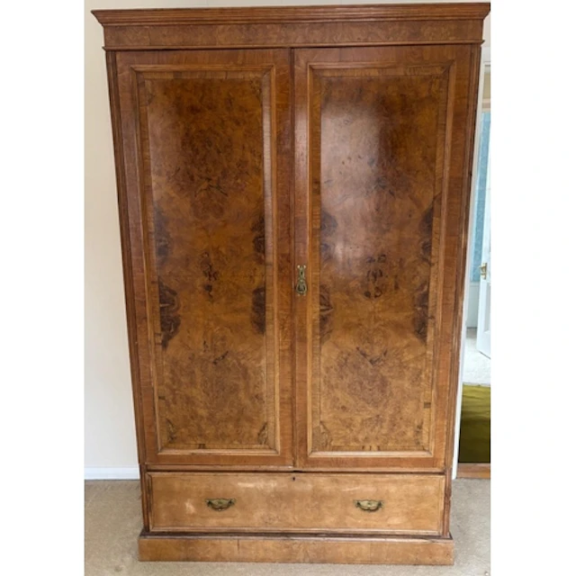 A burr walnut two door wardrobe with drawer under, brass fit...