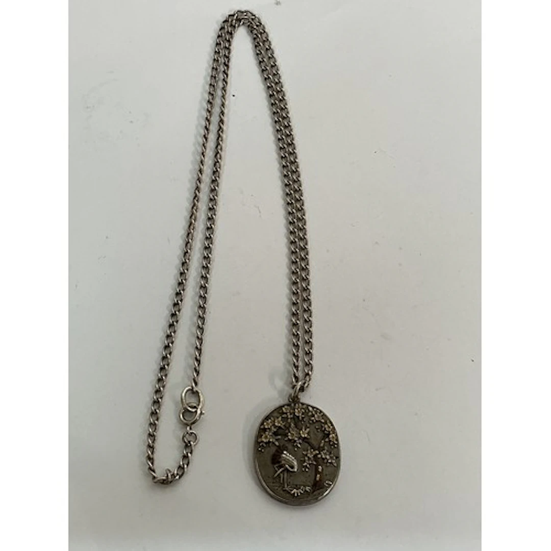 A Japanese style pendant necklace decorated in relief with a...