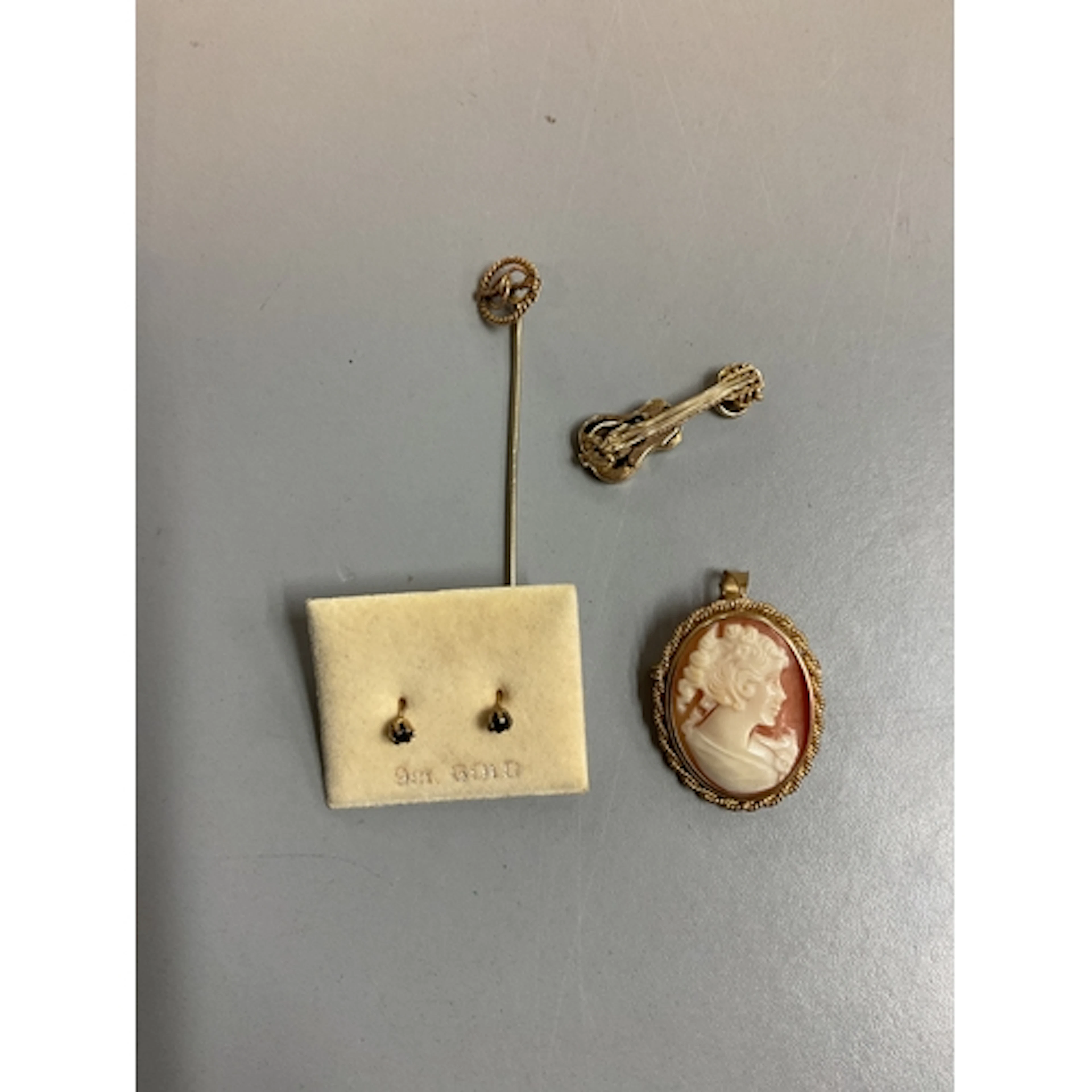 9 ct cameo, guitar charm, earrings and stick pin. Weight, 7....