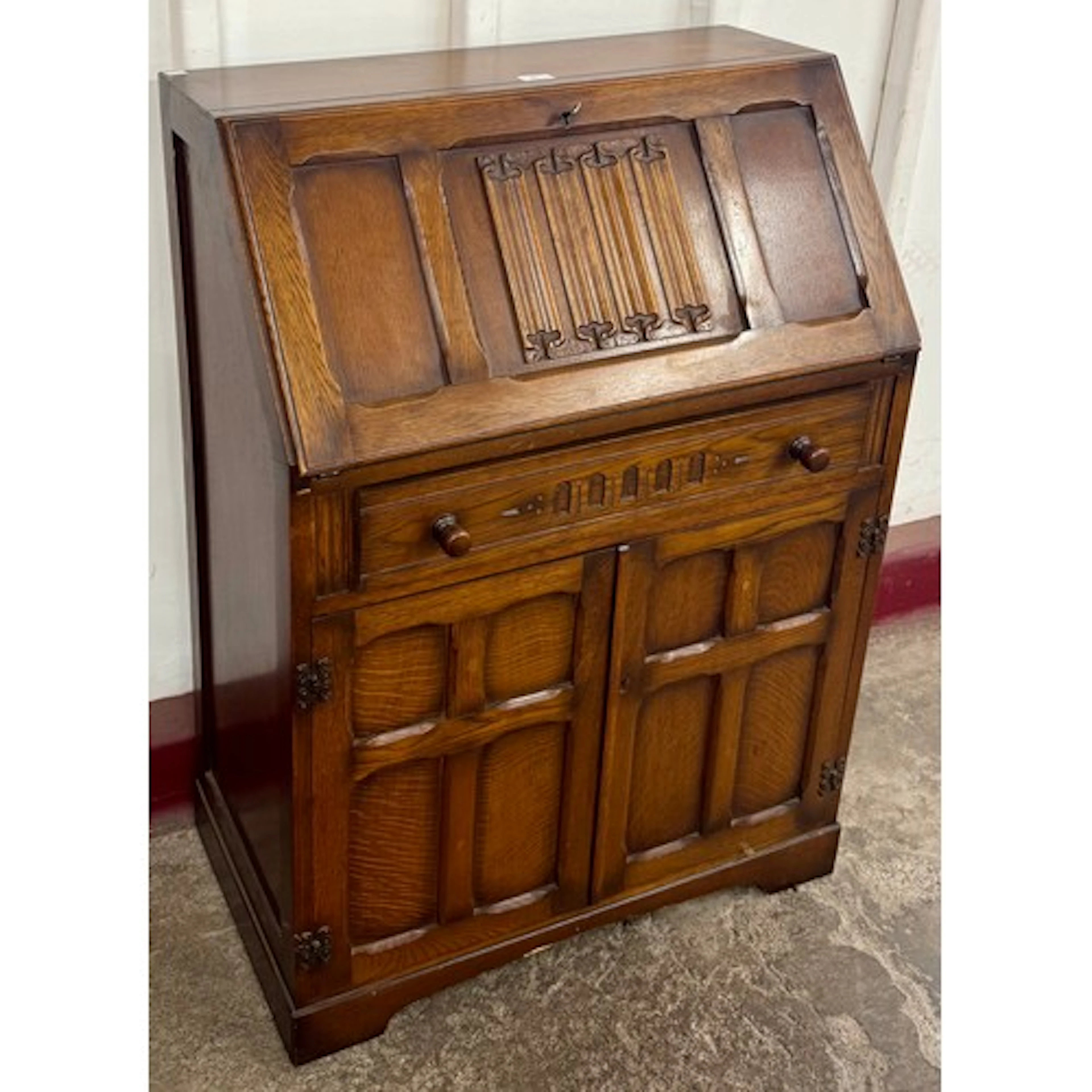 A 17th Century style oak linenfold panel bureau