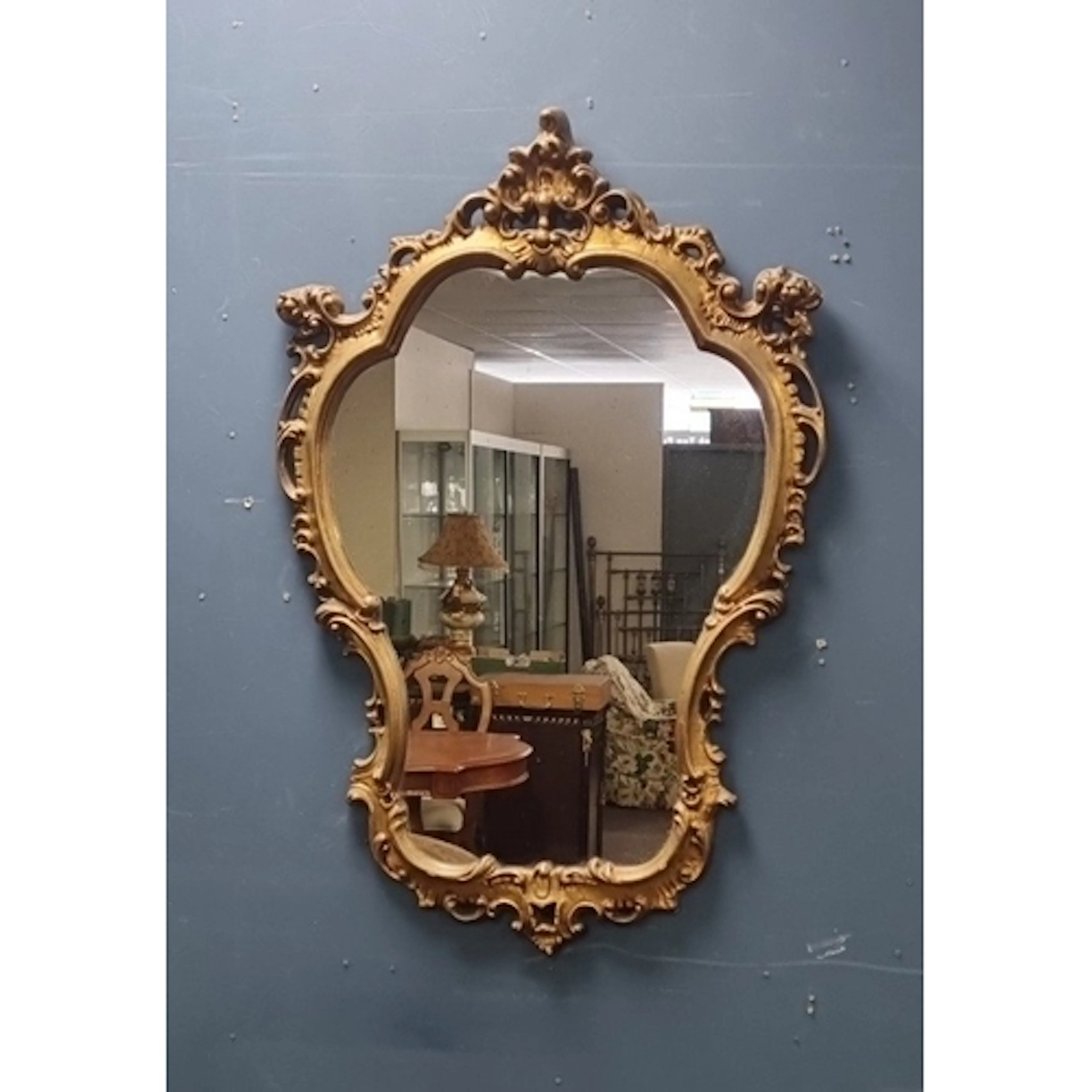 Ornate gilt-framed shaped wall mirror with decorative frameH...