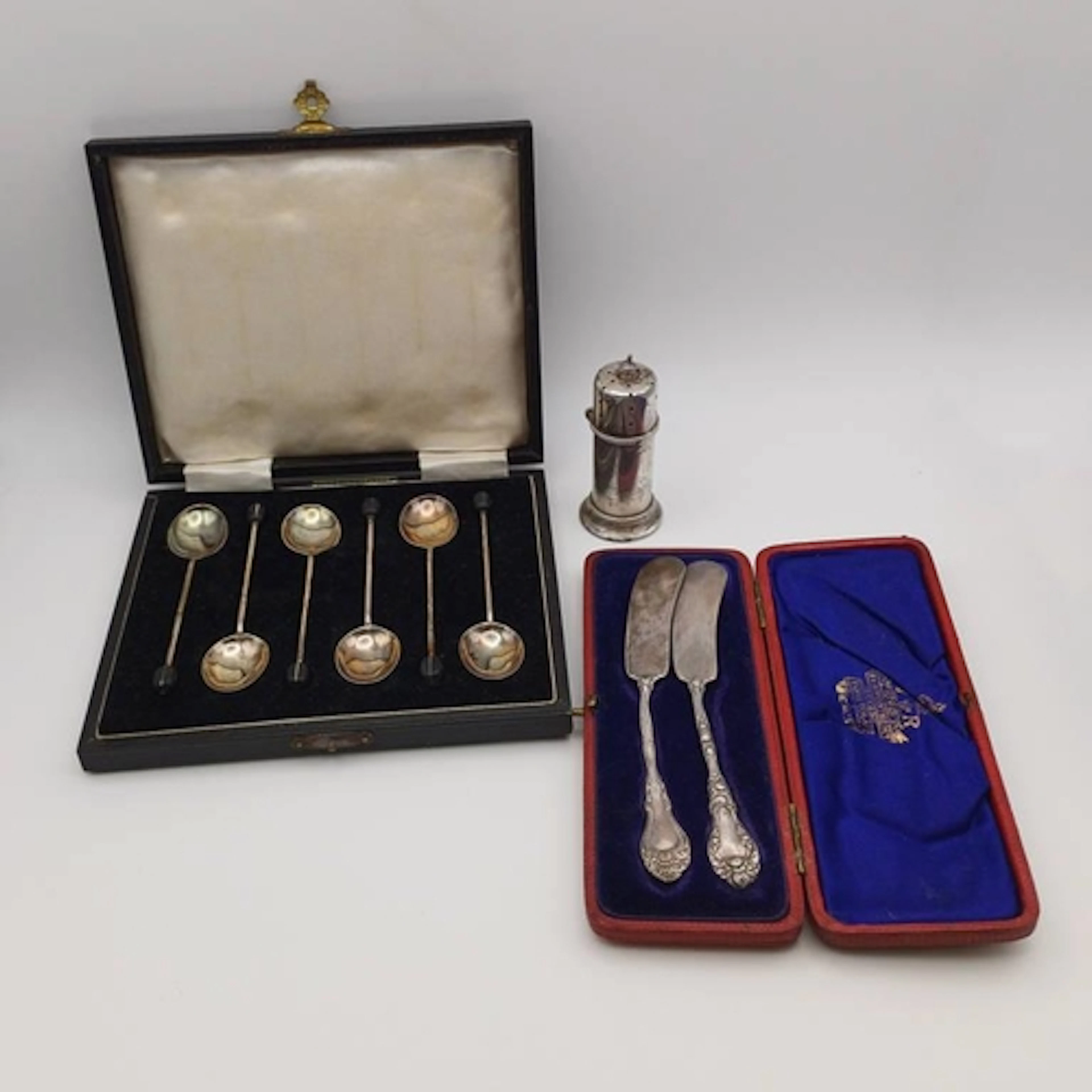 A CASED PAIR OF AMERICAN SILVER BUTTER KNIVES WITH IMPORT MA...