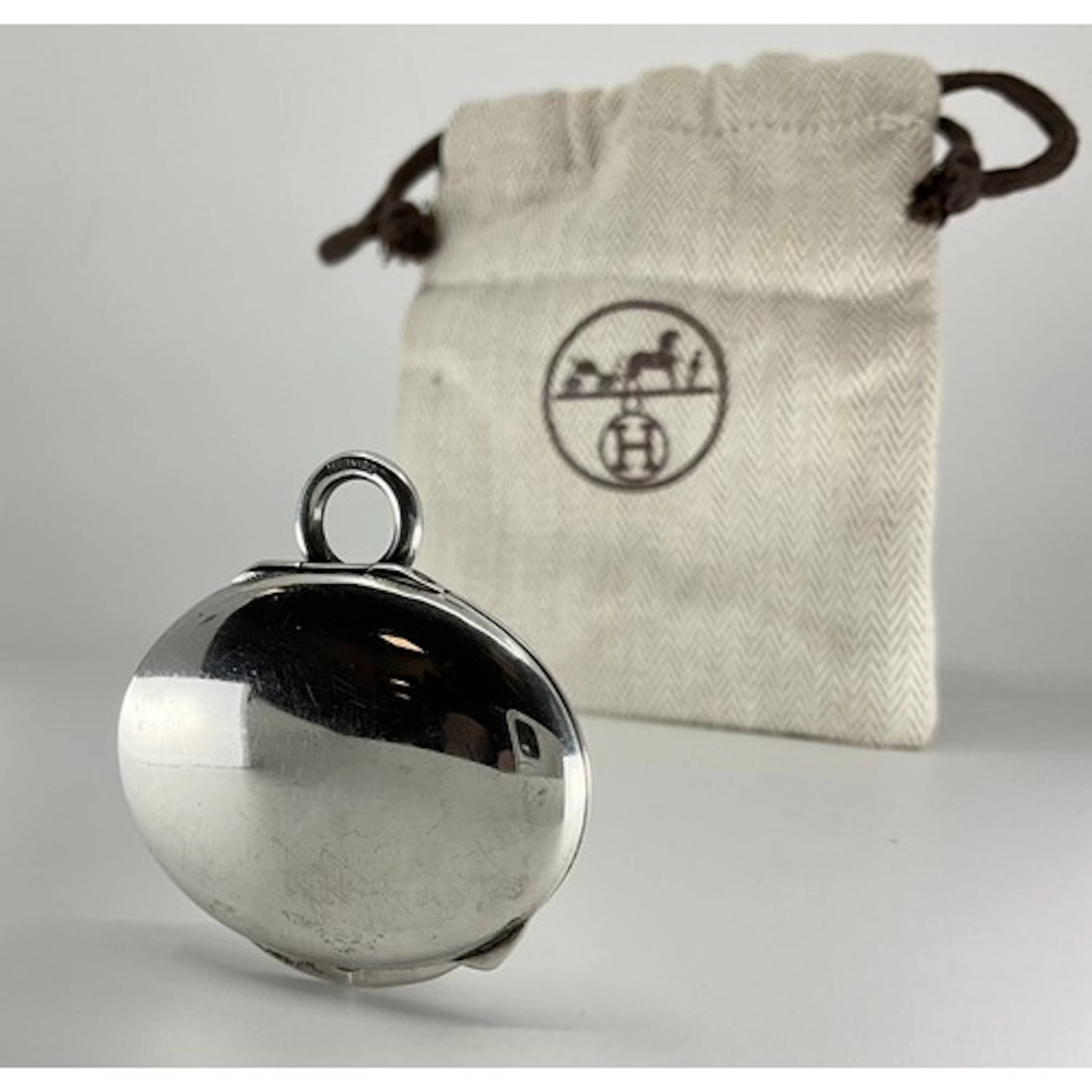 Hermes - a silver pill box/compact pendant, oval polished bo...