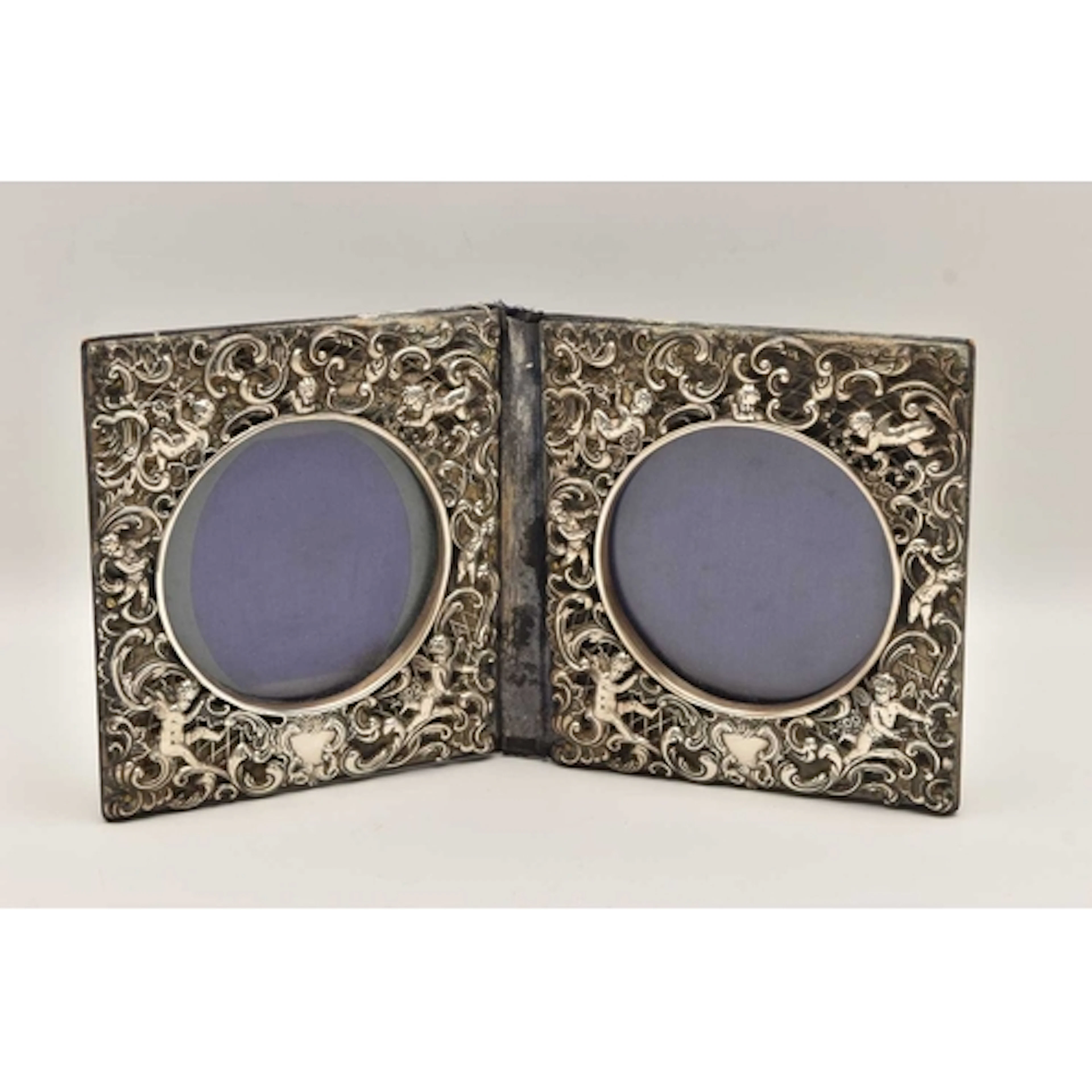 A DOUBLE PHOTO FRAME, white metal depicting cherubs with scr...