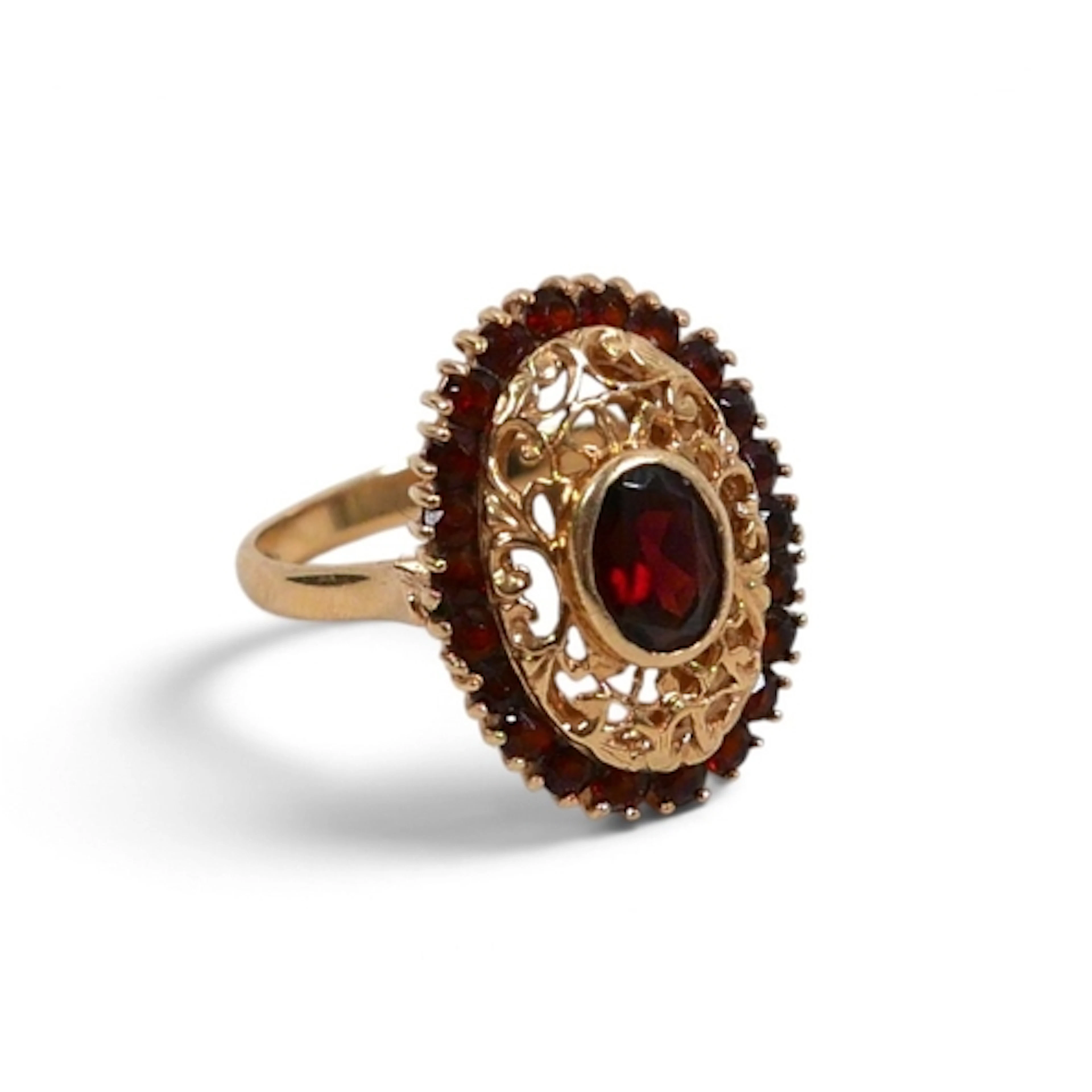 AN 18CT YELLOW GOLD GARNET RING. open work design with a cen...
