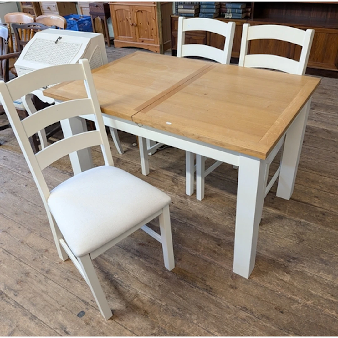 A modern light oak dining table on cream painted base with t...