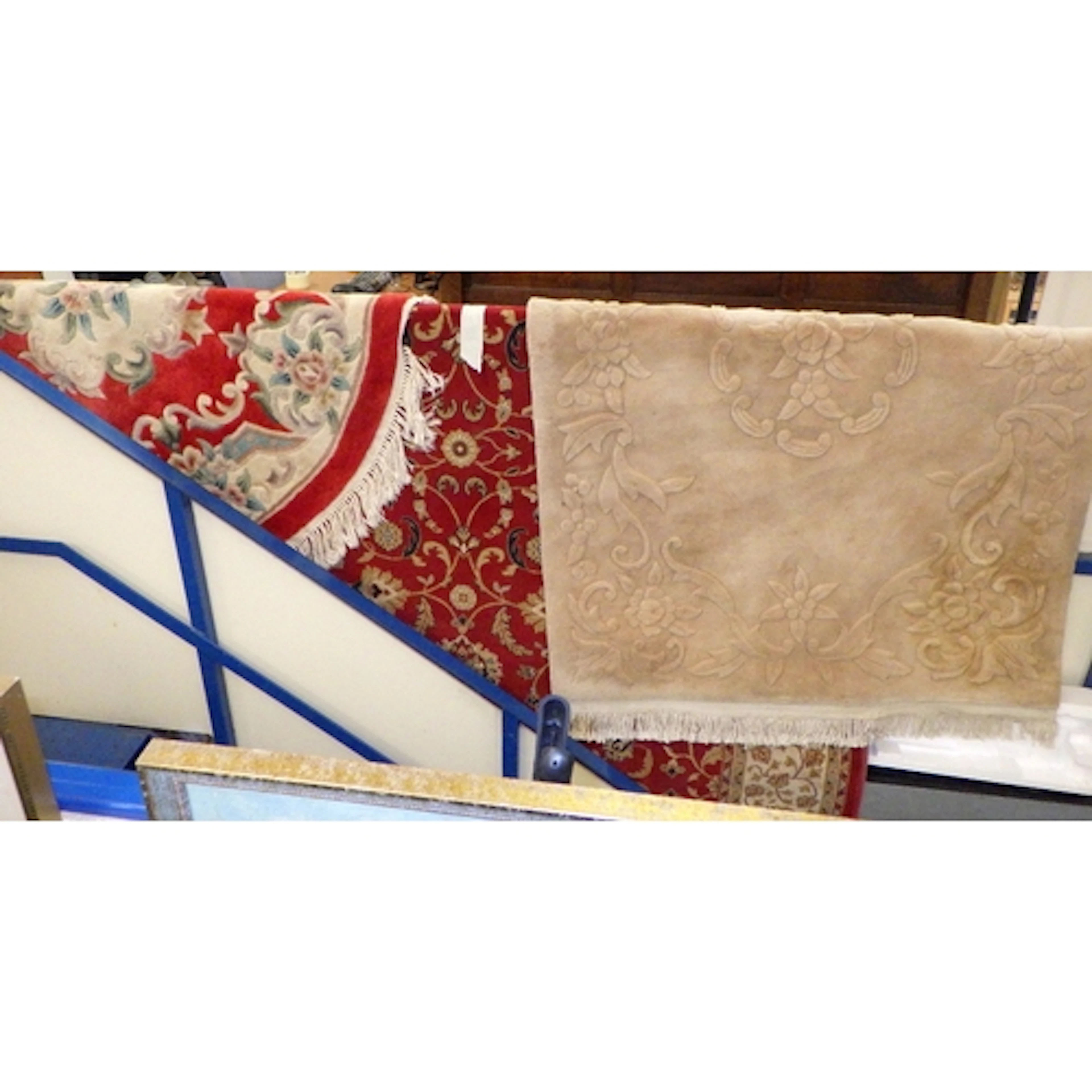 A large machine made red rug together with two Oriental rugs...