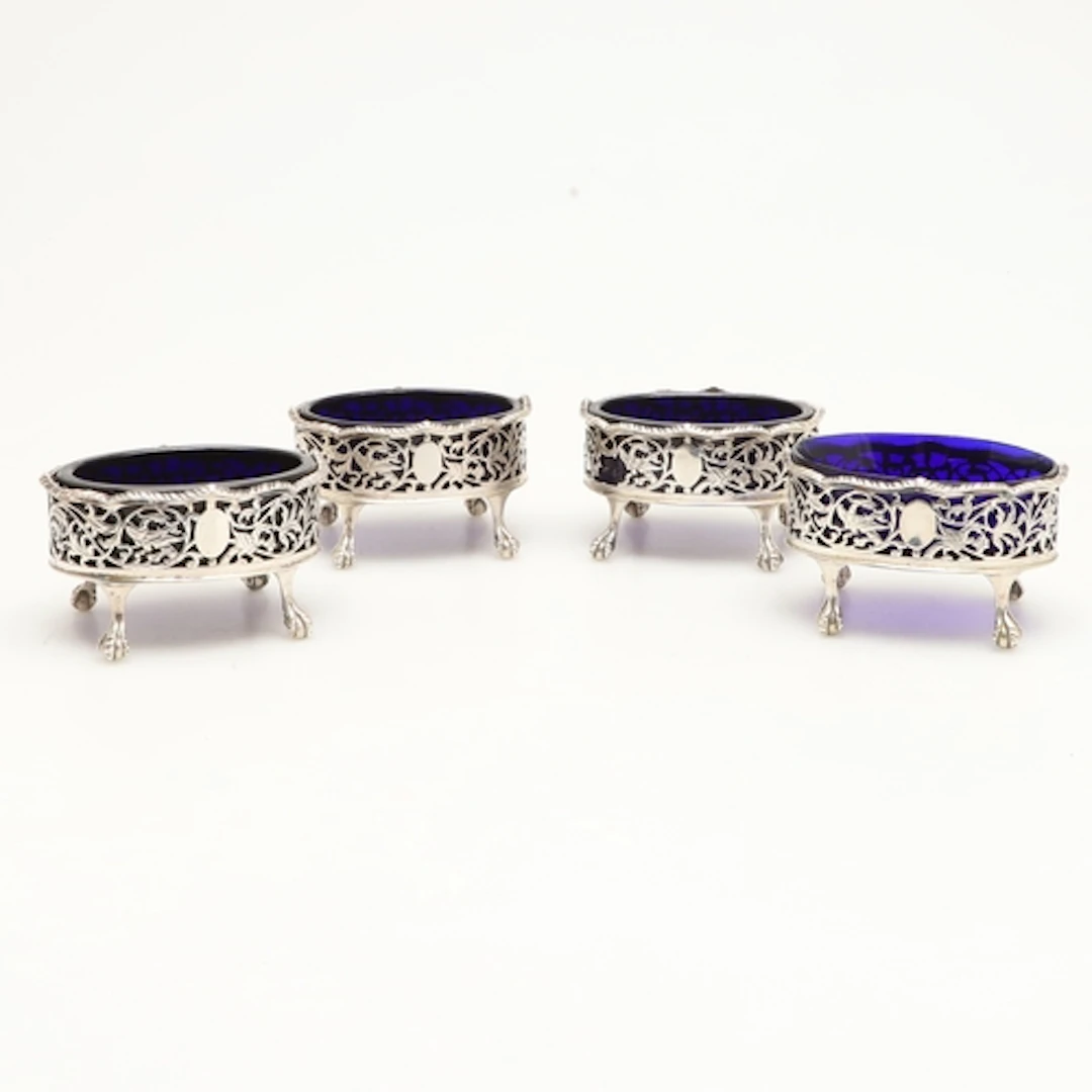 A SET OF FOUR EARLY GEORGE III SILVER SALTS. Of oval form on...