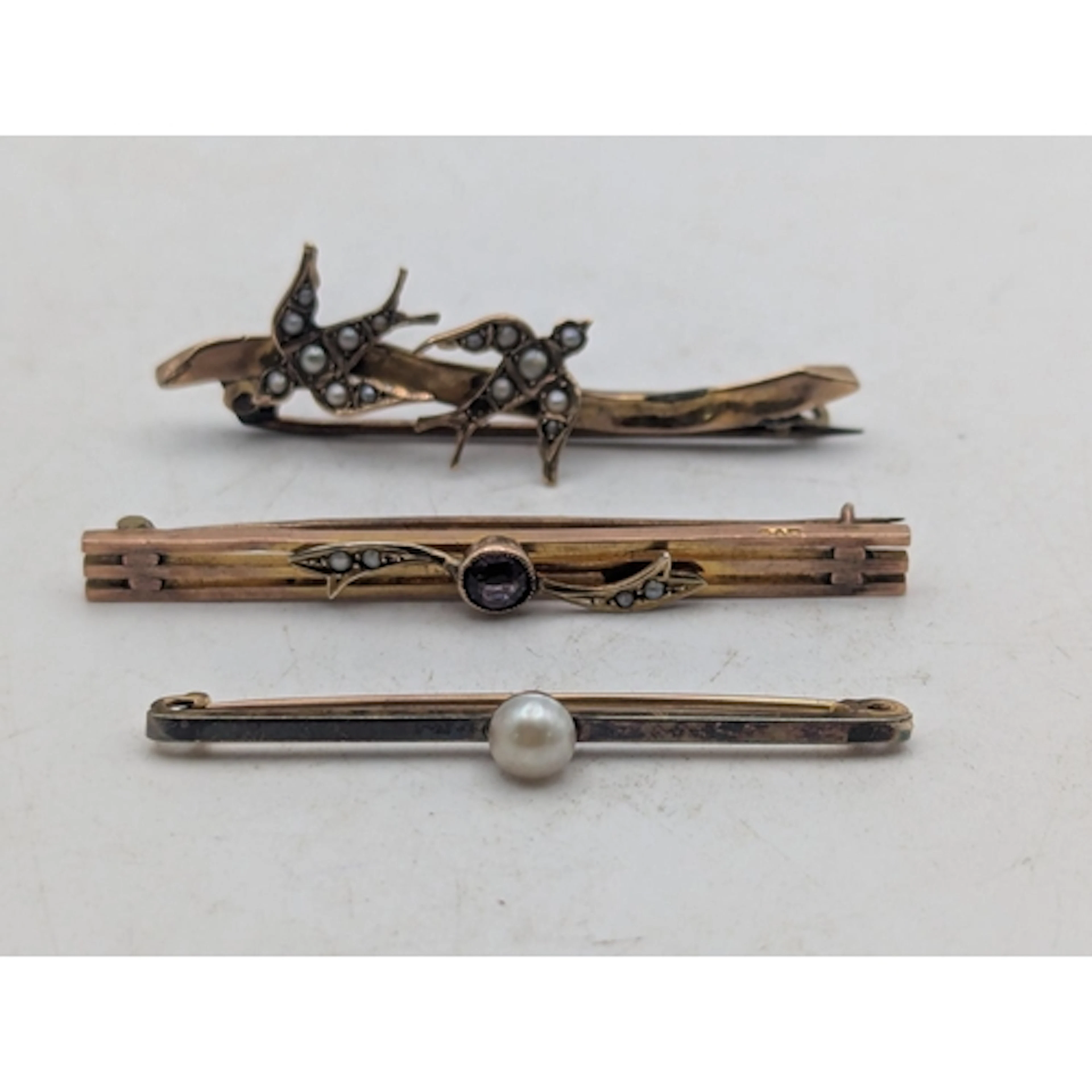 Three 9ct gold bar brooches to include a Victorian seed pear...