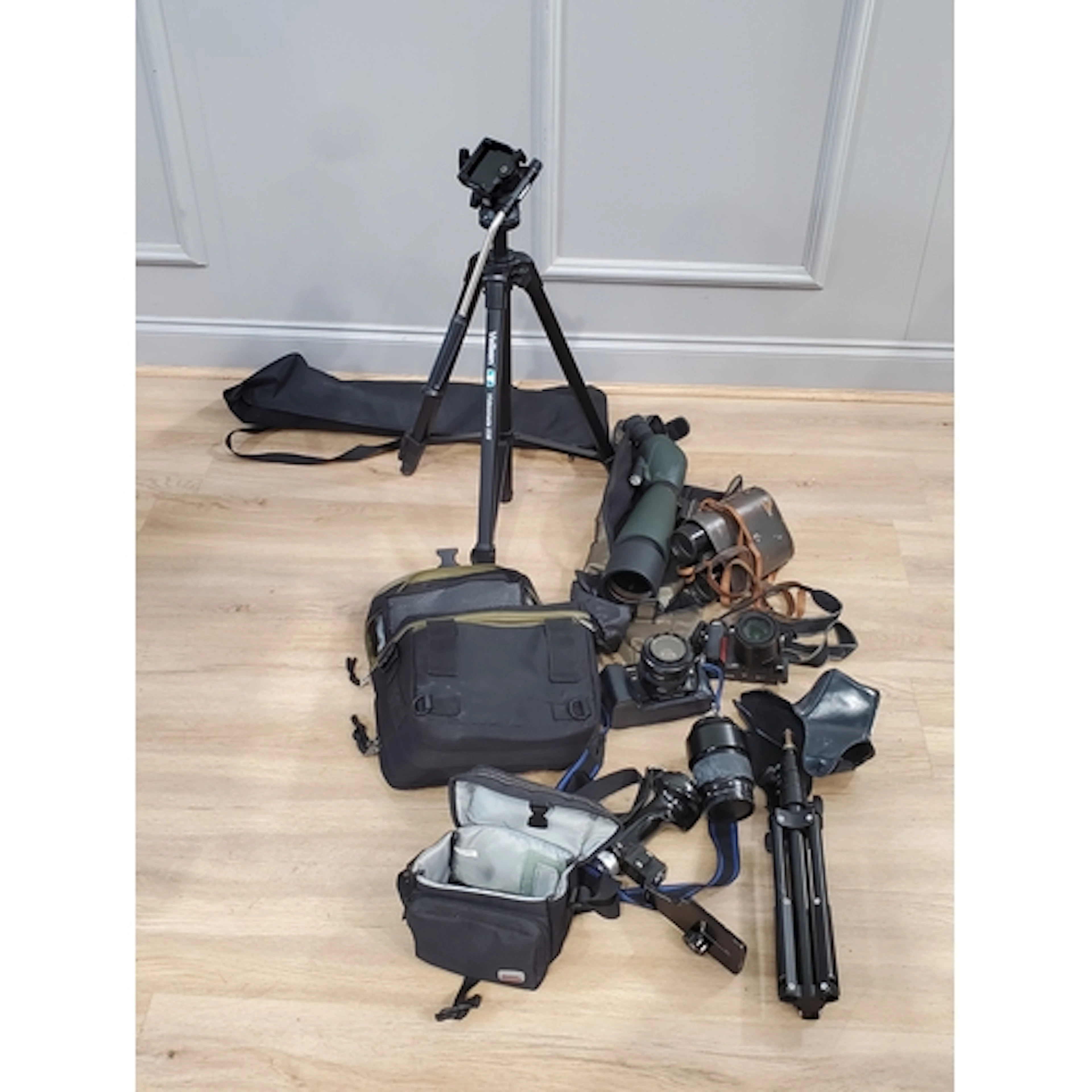 A box containing various spotting scopes, tripods, cameras e...