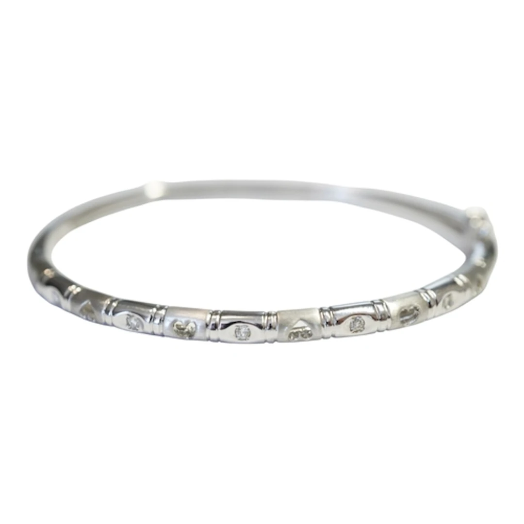 A modern 750 white metal and five stone diamond set hinged b...