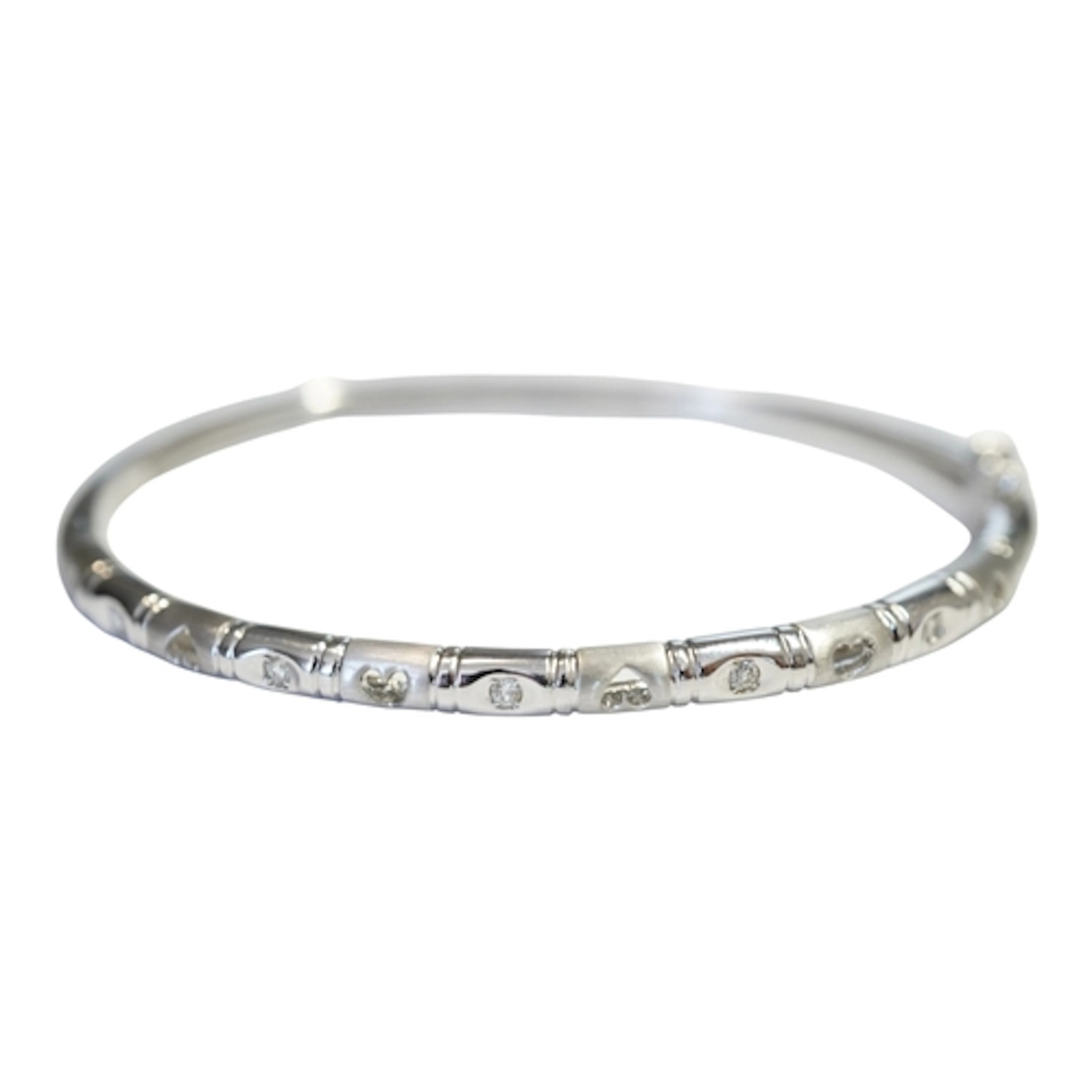 A modern 750 white metal and five stone diamond set hinged b...