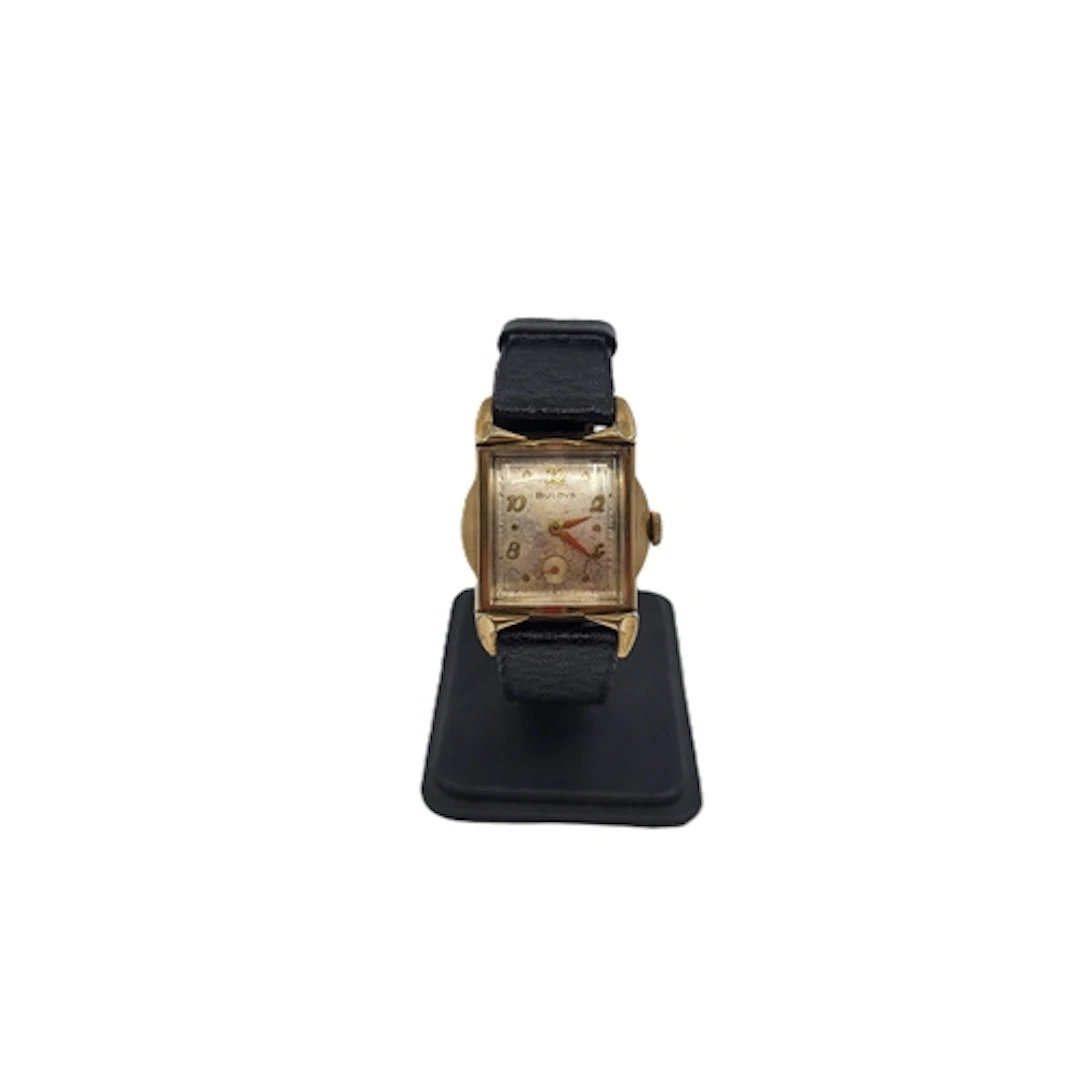 A VINTAGE BULOVA TANK, gold-plated watch, black leather stra...