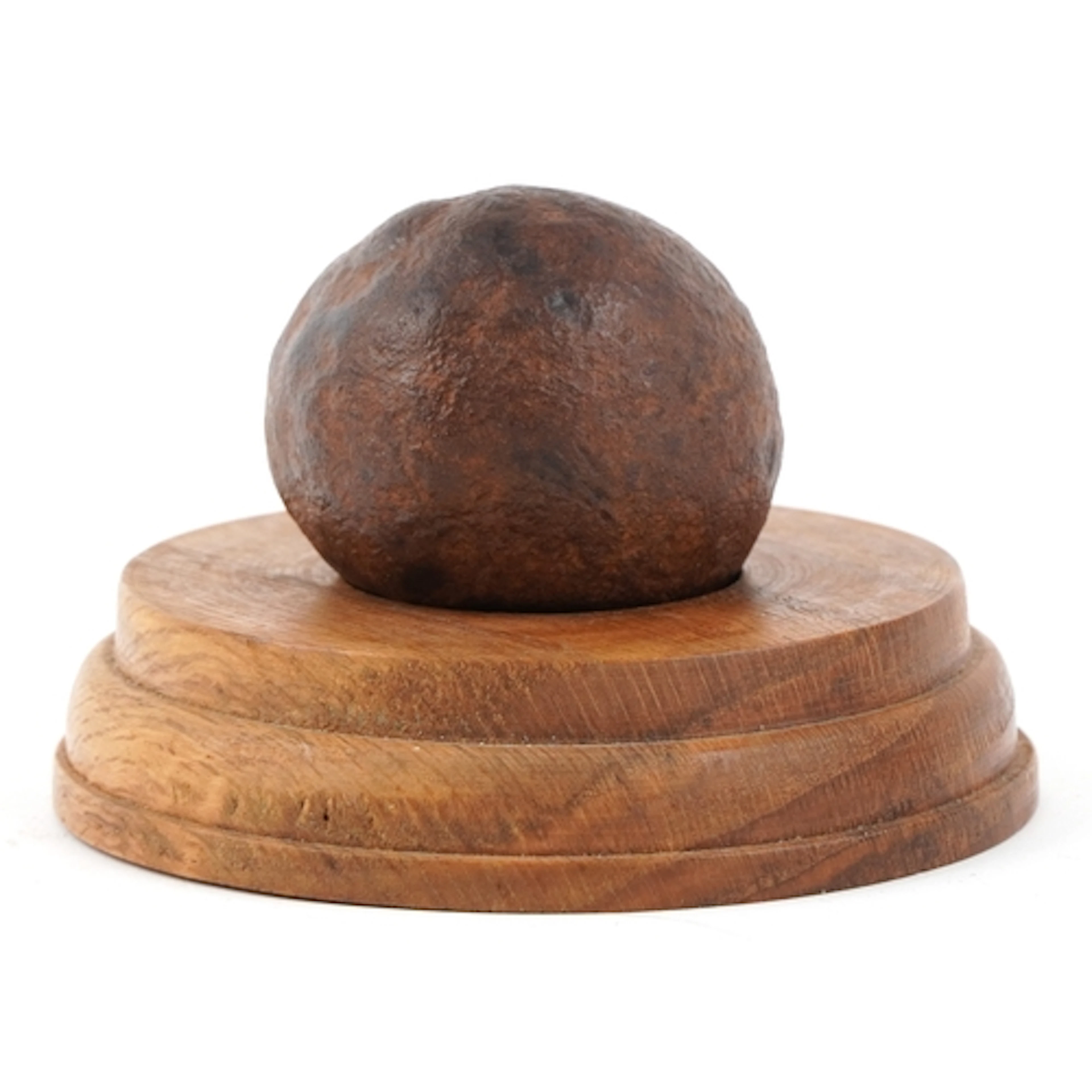 A 'meteorite' on a turned wood base, 5.5cm in diameter.