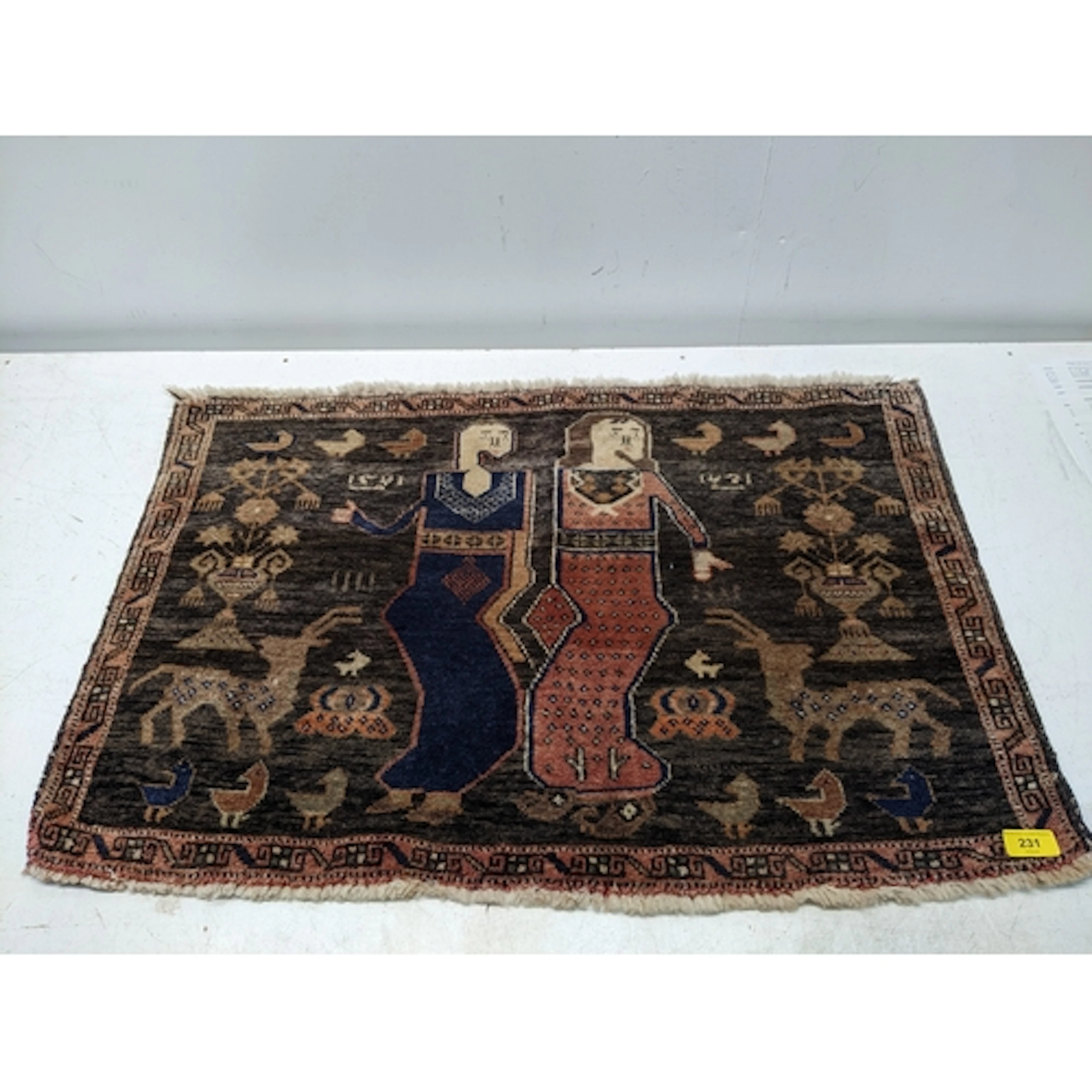 A small Persian hand woven tribal prayer rug, two figures to...