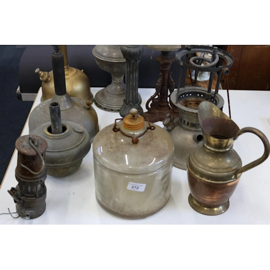 Part paraffin lamps, a brass and copper jug, a miners' lamp,...