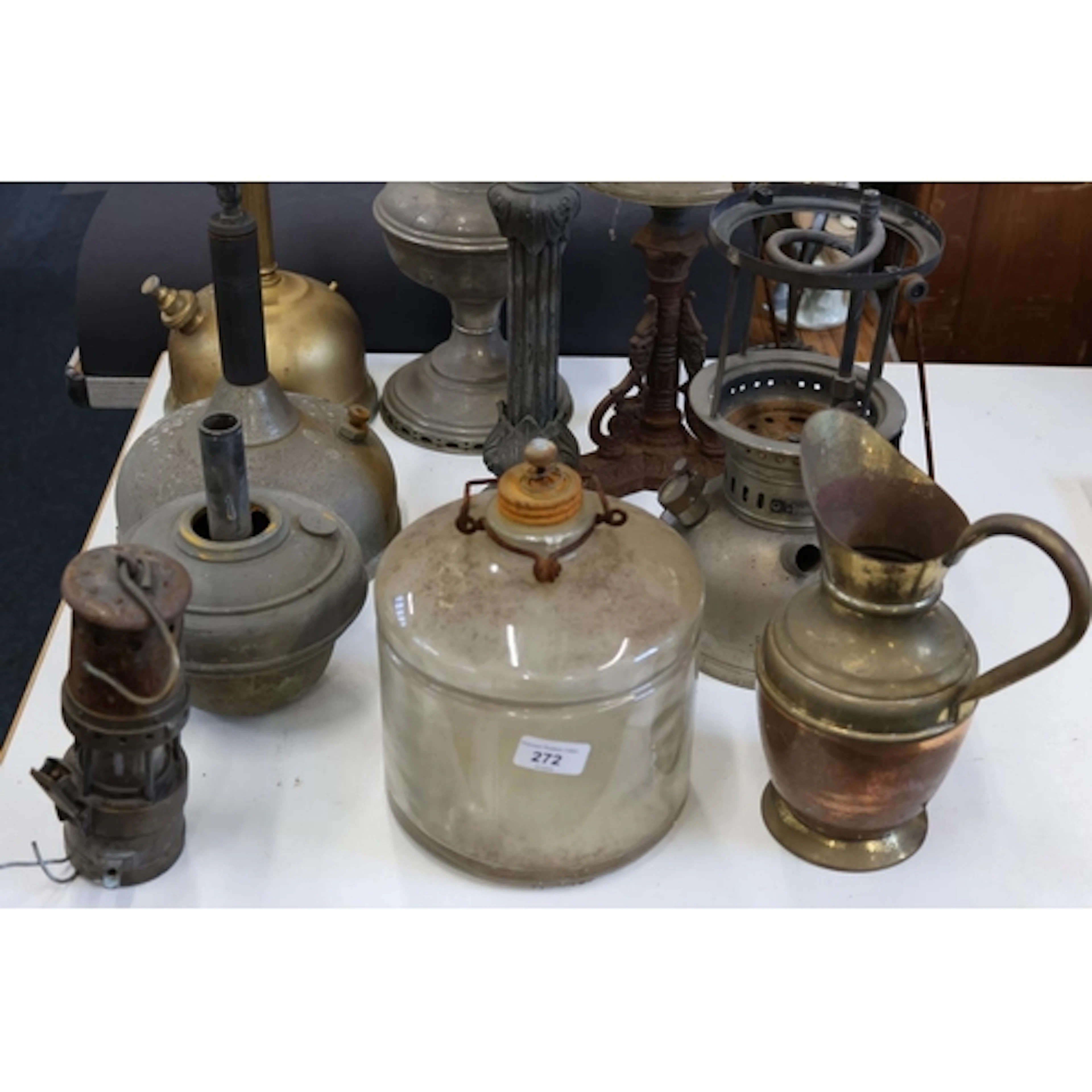 Part paraffin lamps, a brass and copper jug, a miners' lamp,...