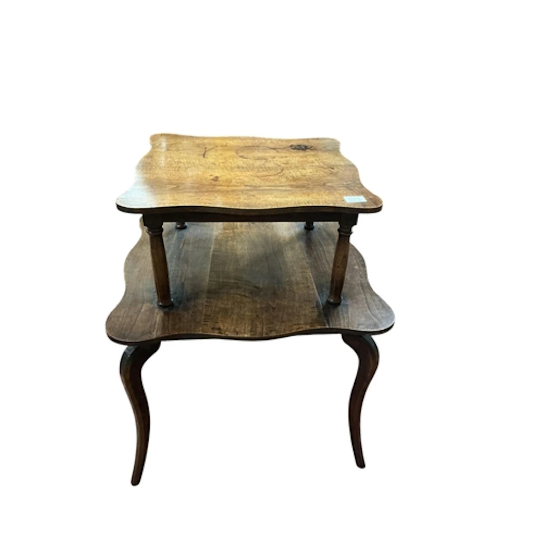 An Edwardian oak two tier occasional table, with shaped edge...