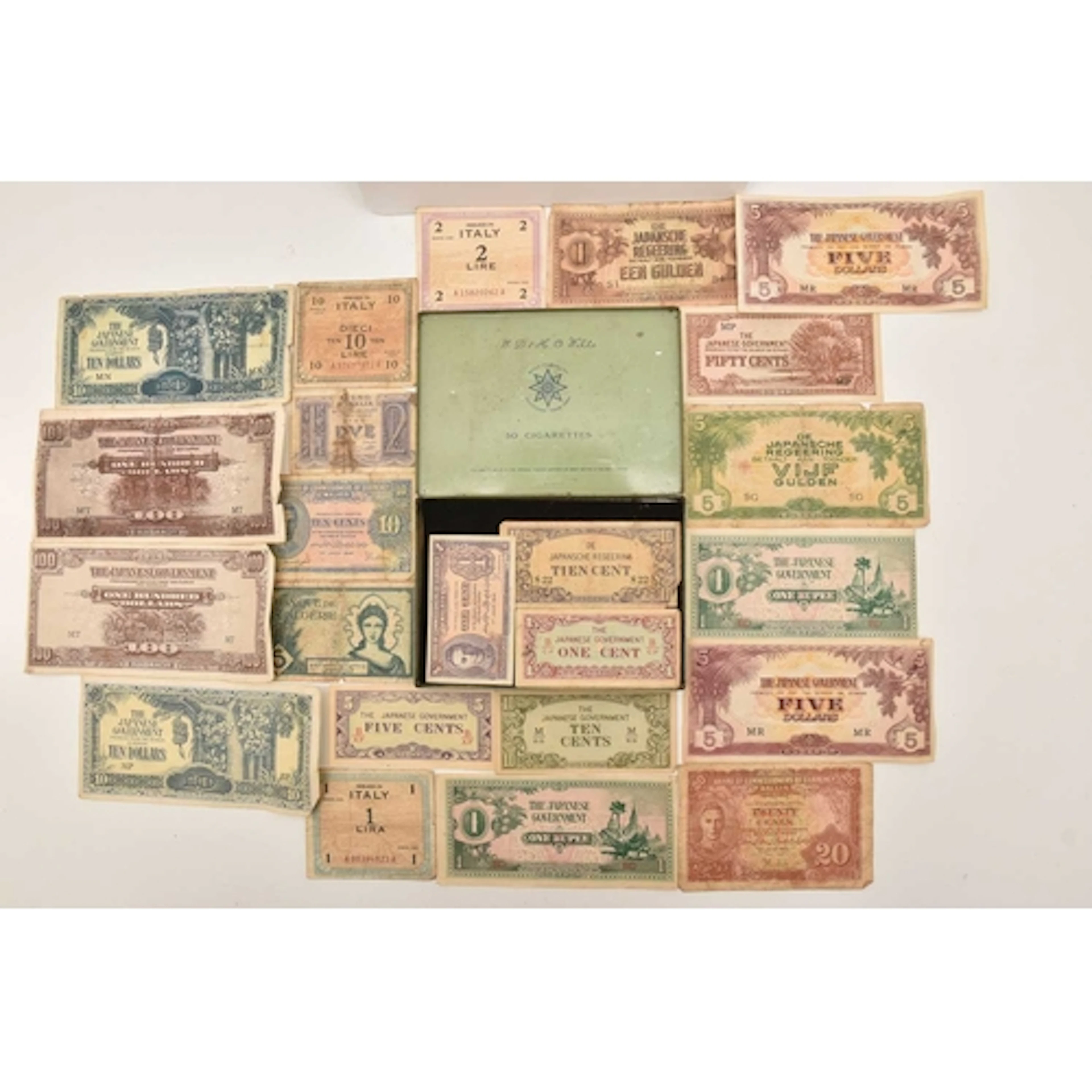 Banknotes. A tin containing a collection of Japanese notes a...