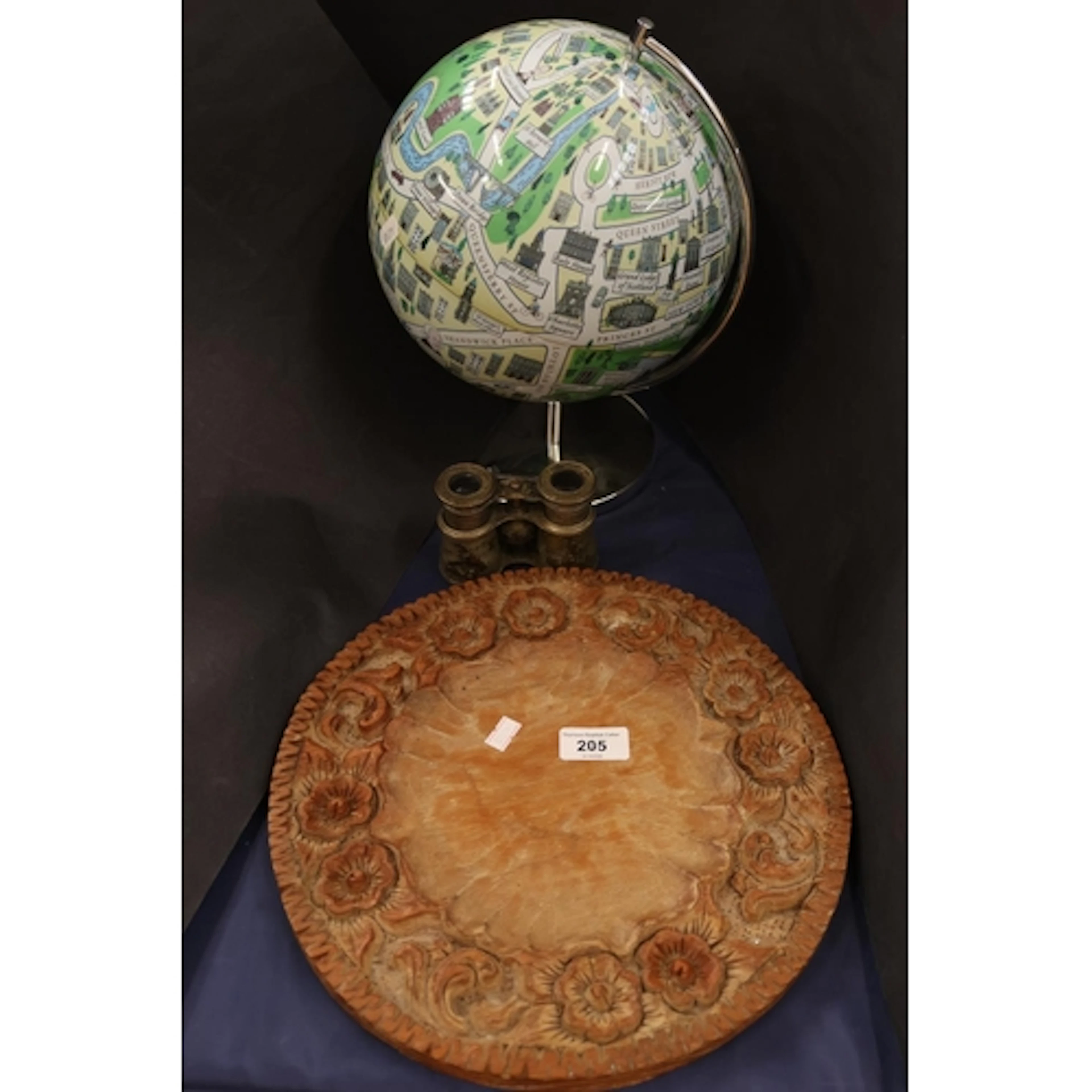 Carved circular tray with foliate design, globe, binoculars.