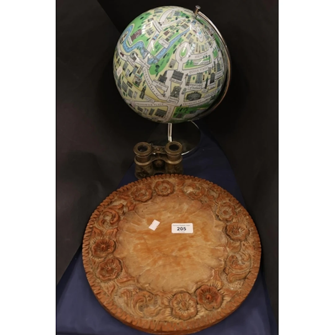 Carved circular tray with foliate design, globe, binoculars.