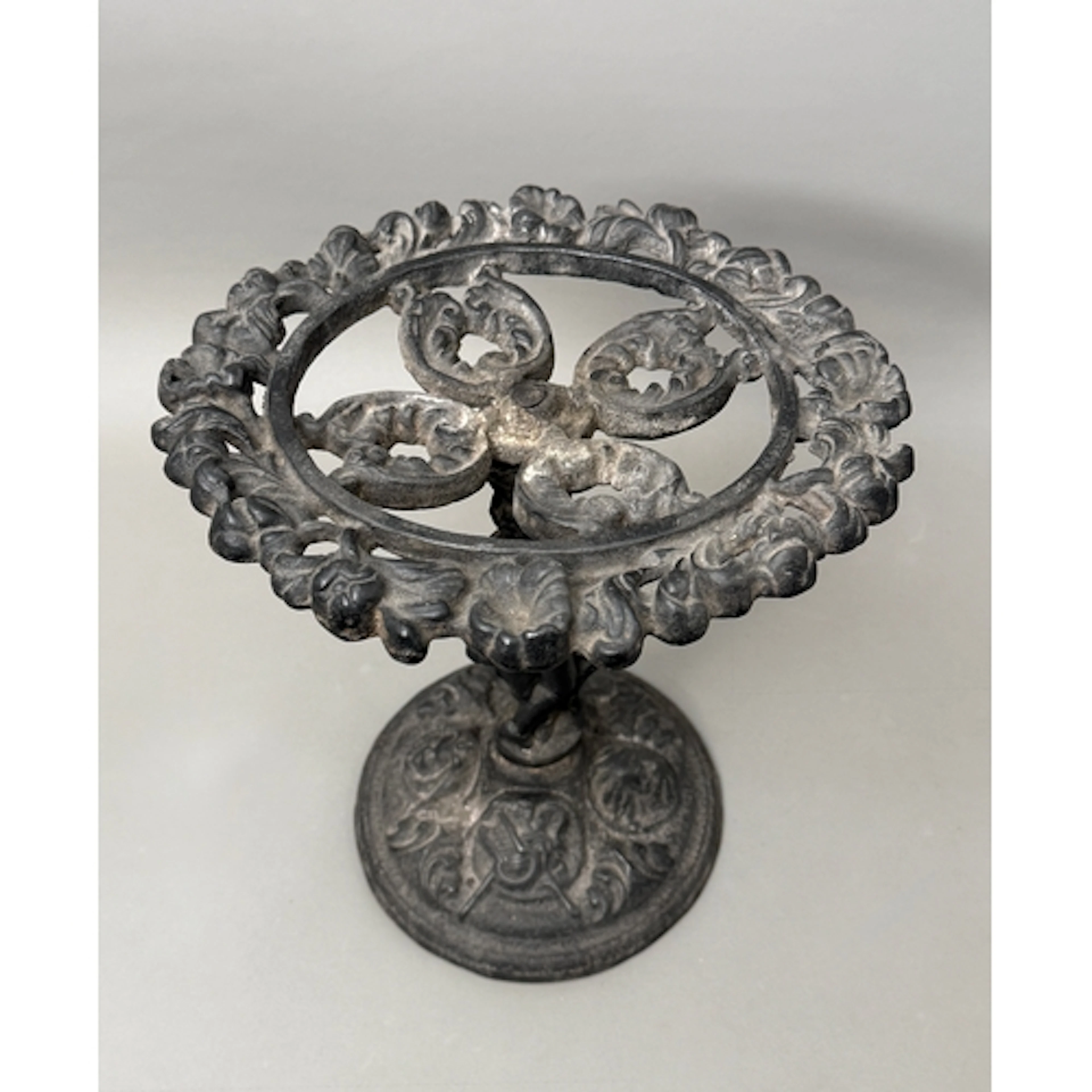 A black cast iron stand - the stem decorated with a standin...