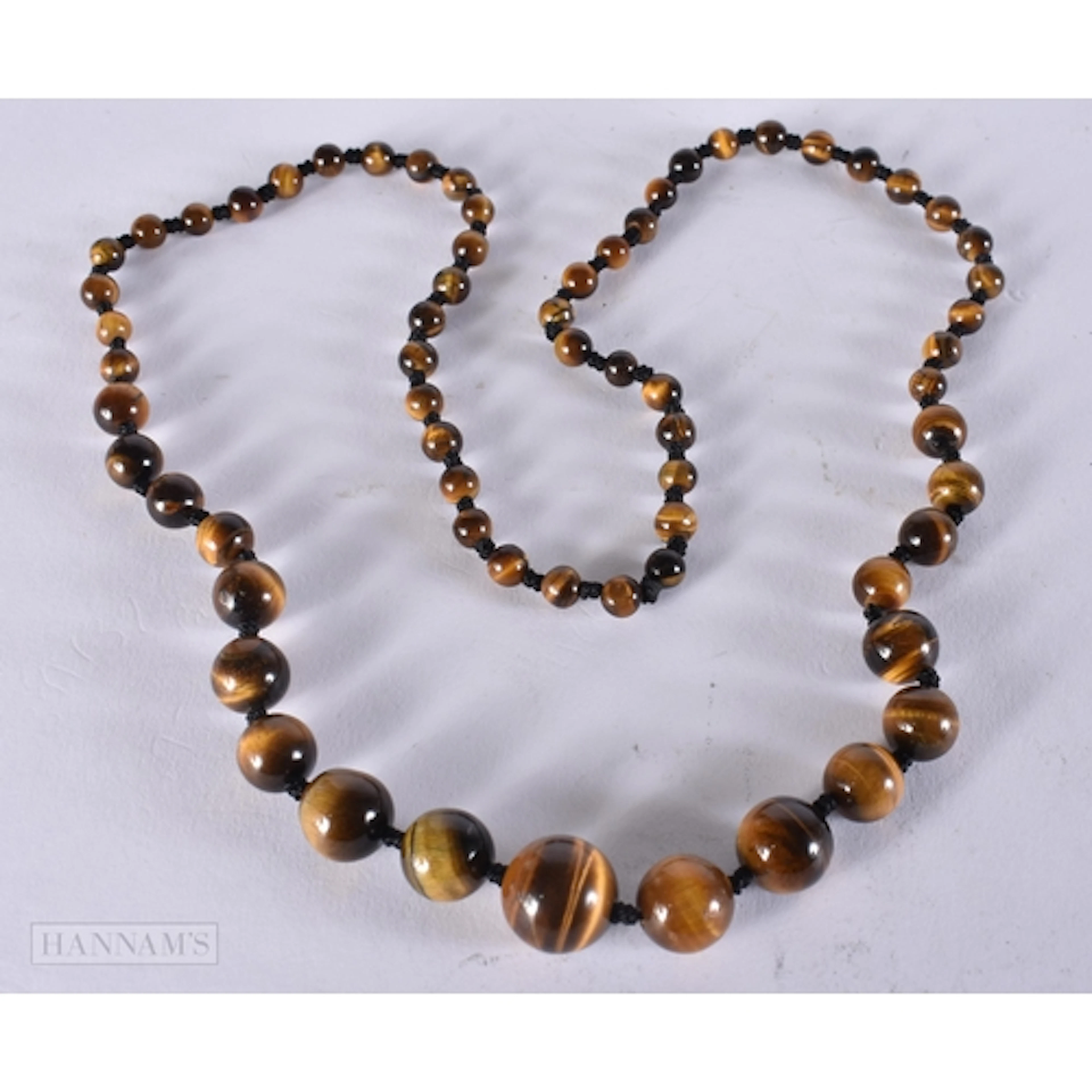 A TIGERS EYE STRING BEAD NECKLACE. 70 cm