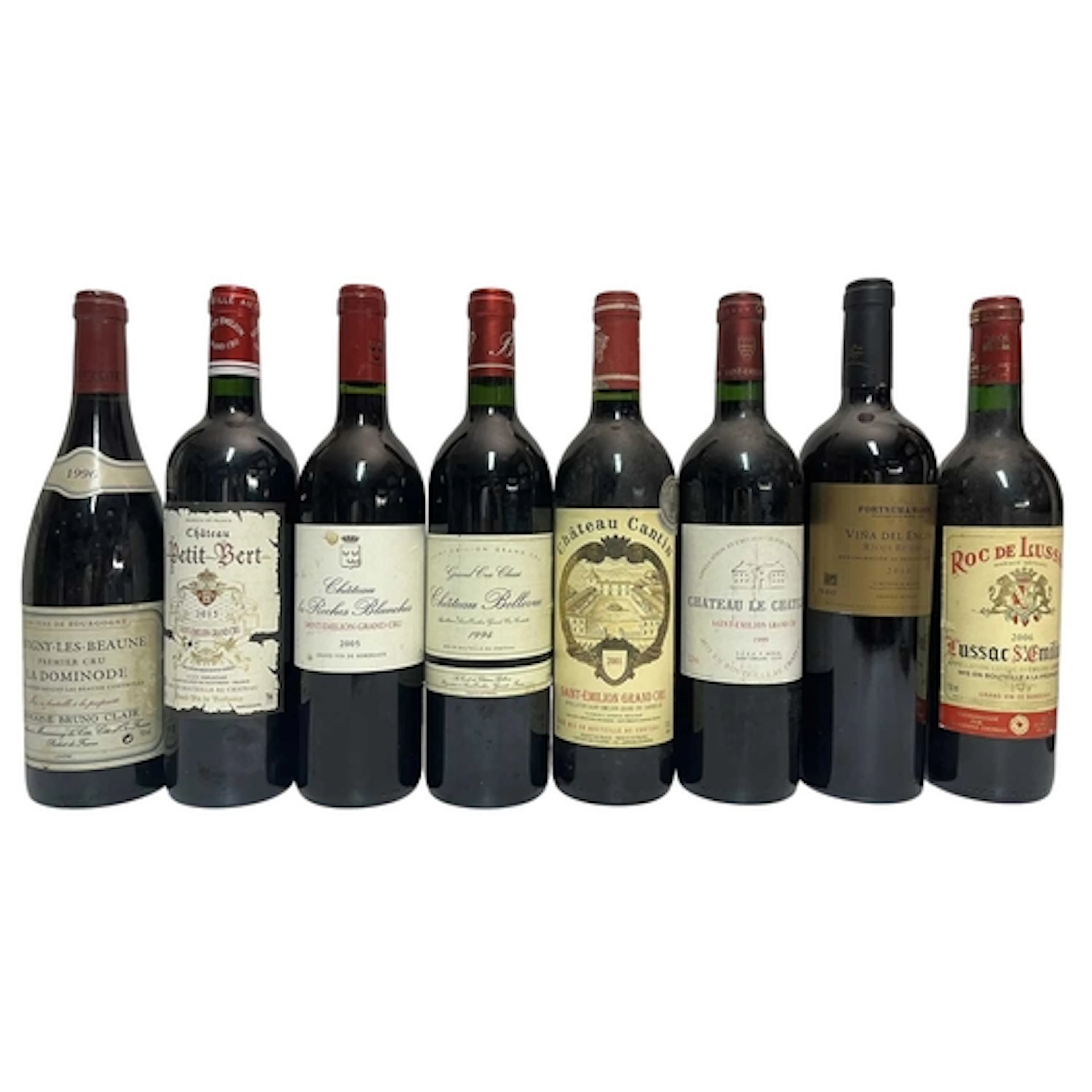 An assortment of eight French and Spanish red wine bottles. ...