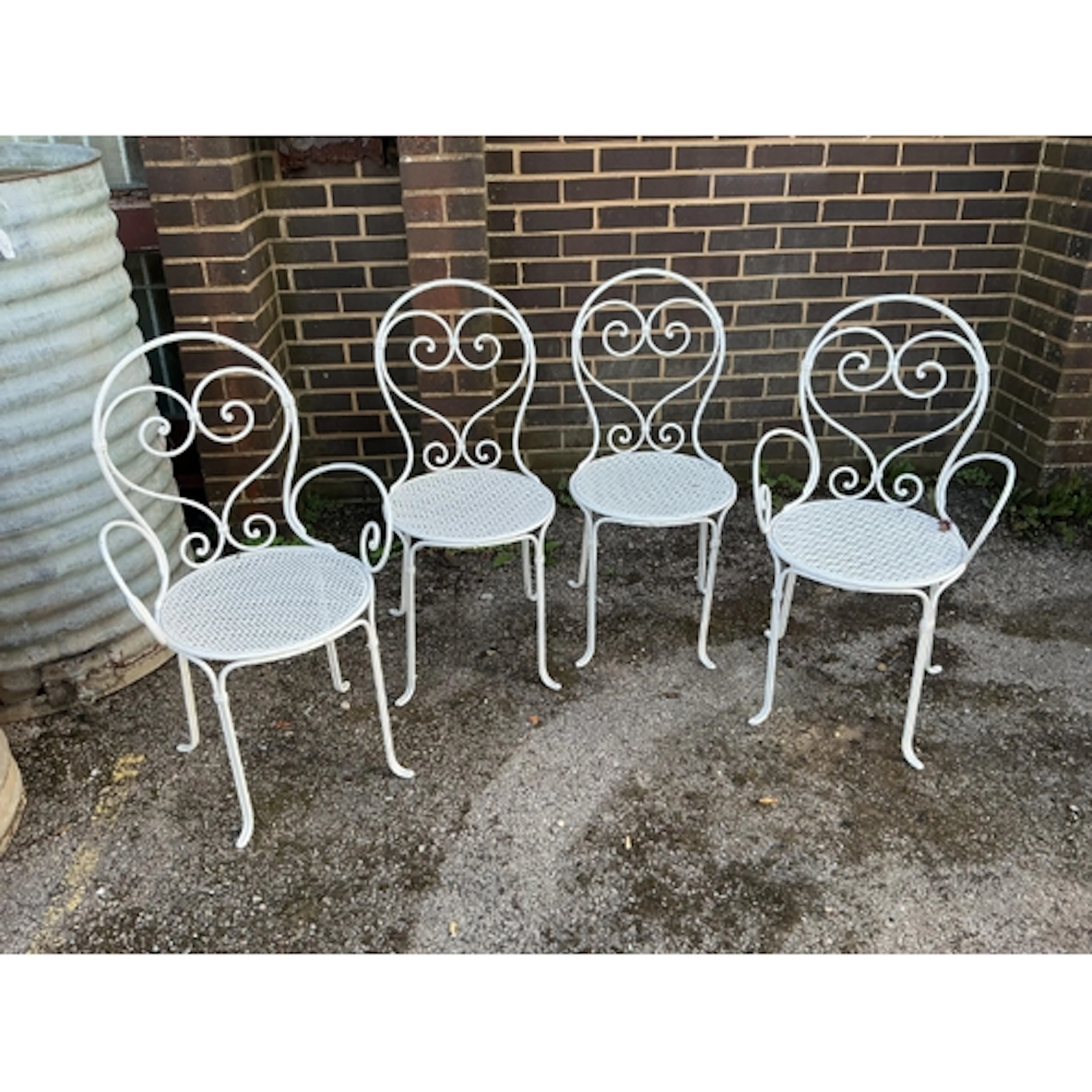 A set of four French wrought iron garden chairs, largest 50c...