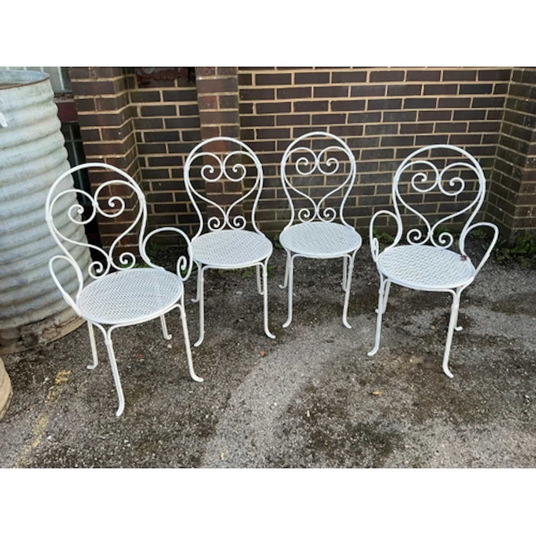 A set of four French wrought iron garden chairs, largest 50c...