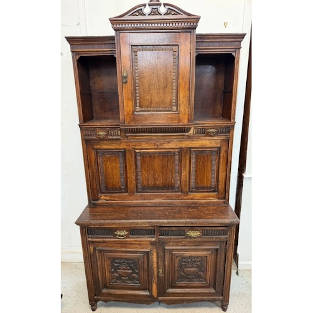 A carved oak court cupboard featuring a pull down bureau H20...